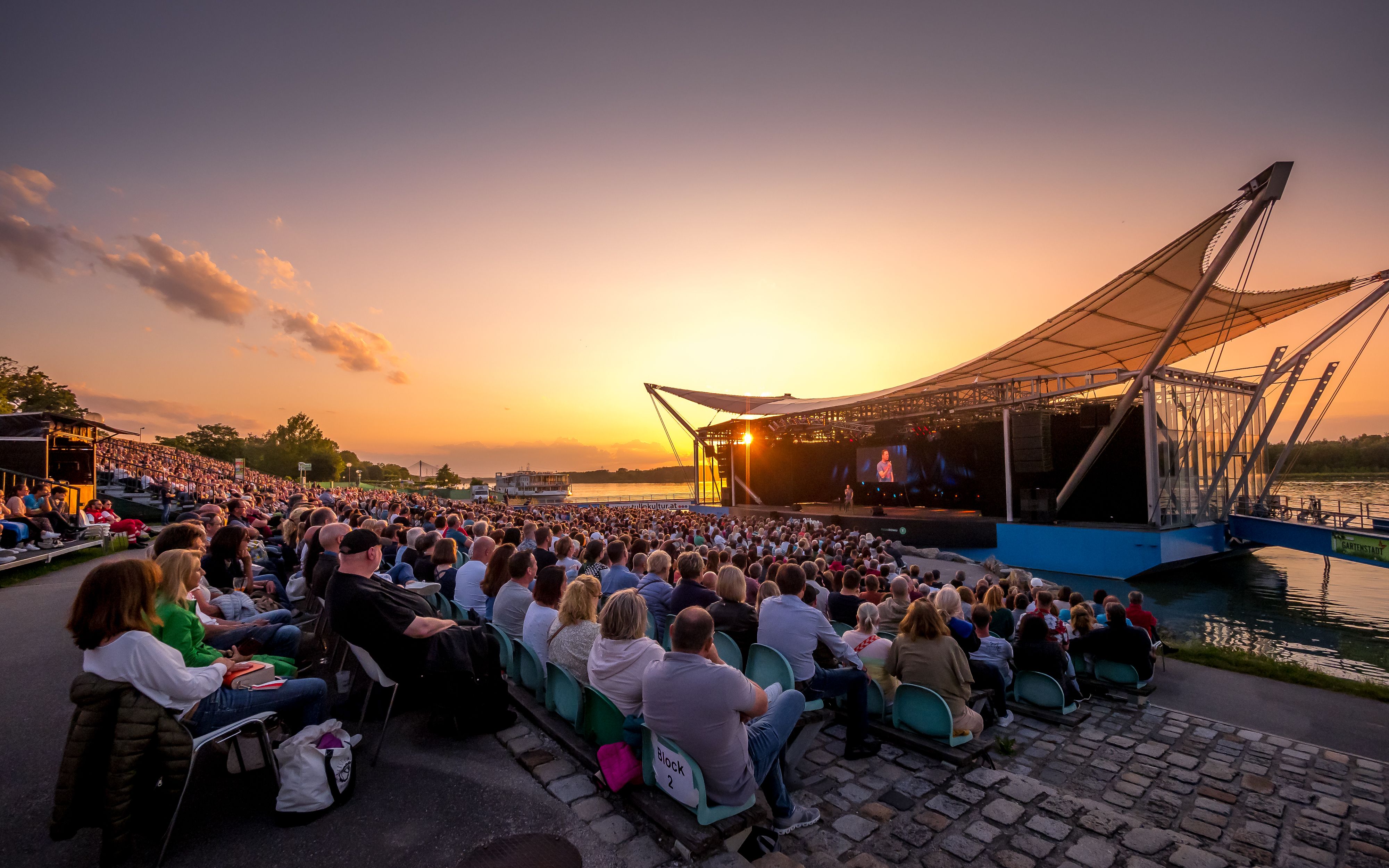 Open-Air-Veranstaltung auf der Donaubühne Tulln bei Sonnenuntergang.