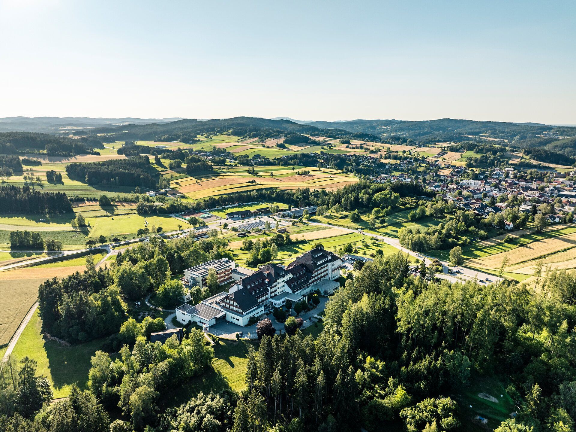 Luftaufnahme des Herz-Kreislauf-Zentrums Groß Gerungs im Waldviertel, umgeben von Wiesen, Feldern, Wald und dem Ort Groß Gerungs.