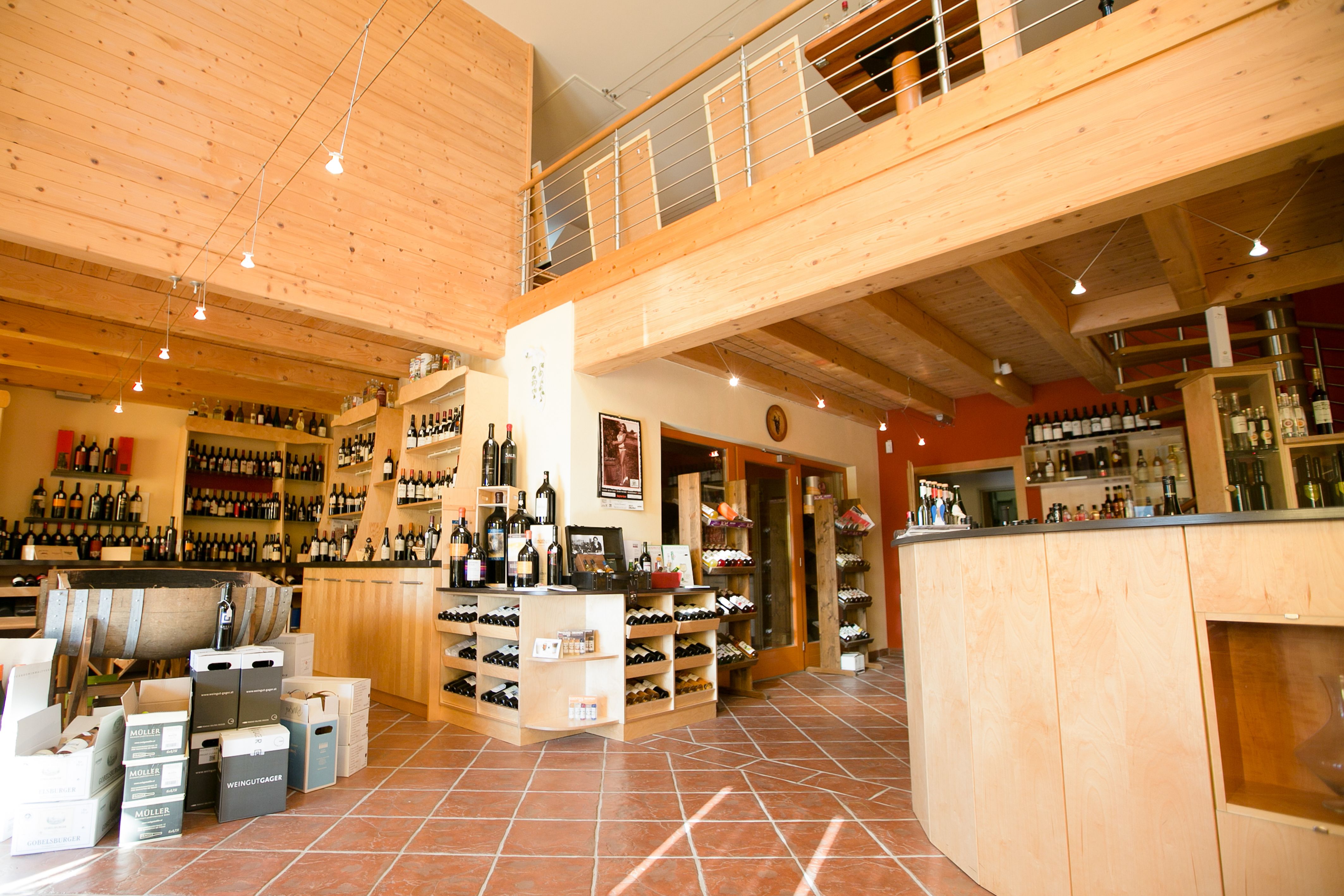 Innenansicht einer Vinothek mit Holzeinrichtung und Weinflaschen.