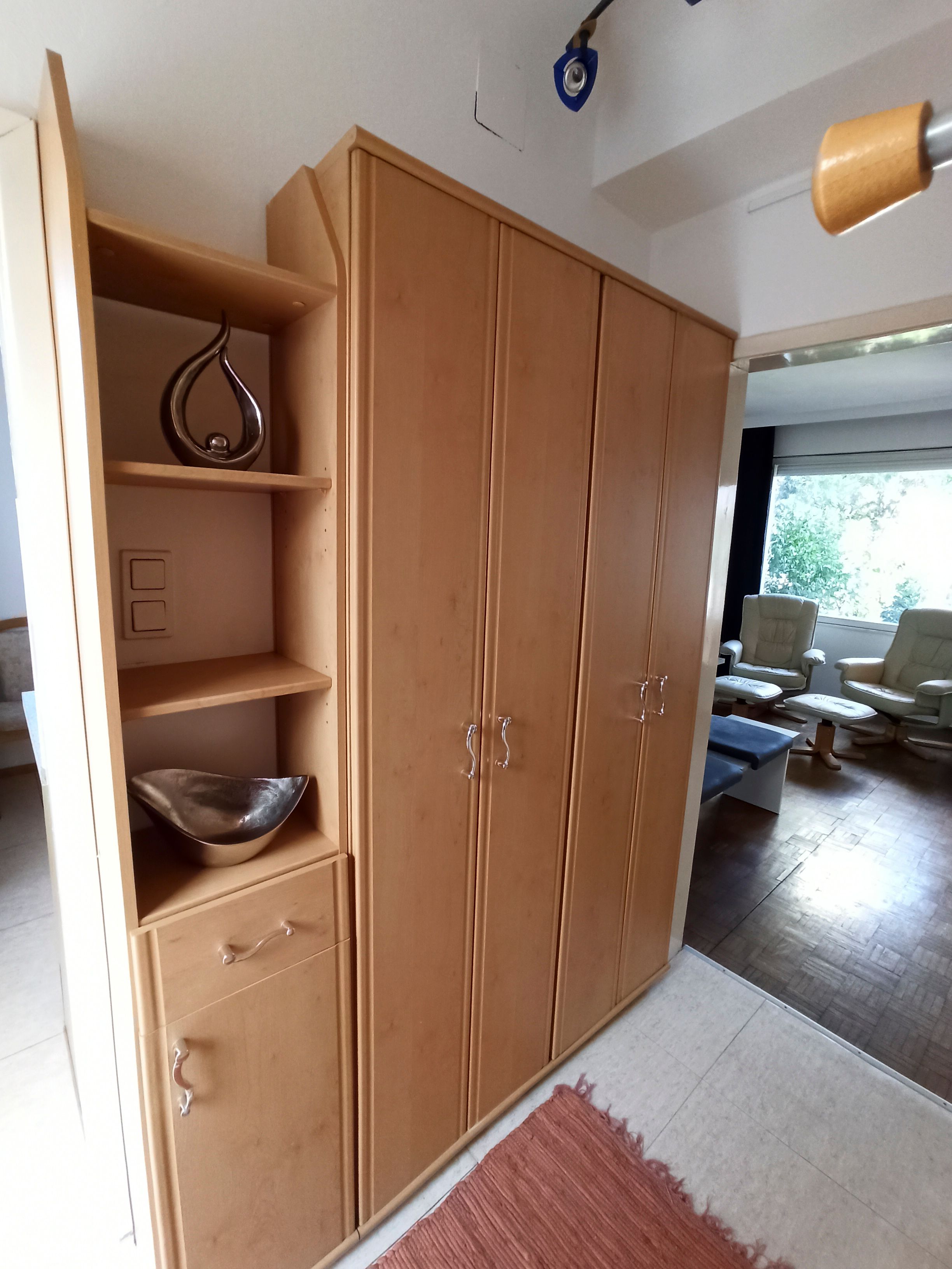 Holzschrank mit Regalen und Schubladen in einem Raum.