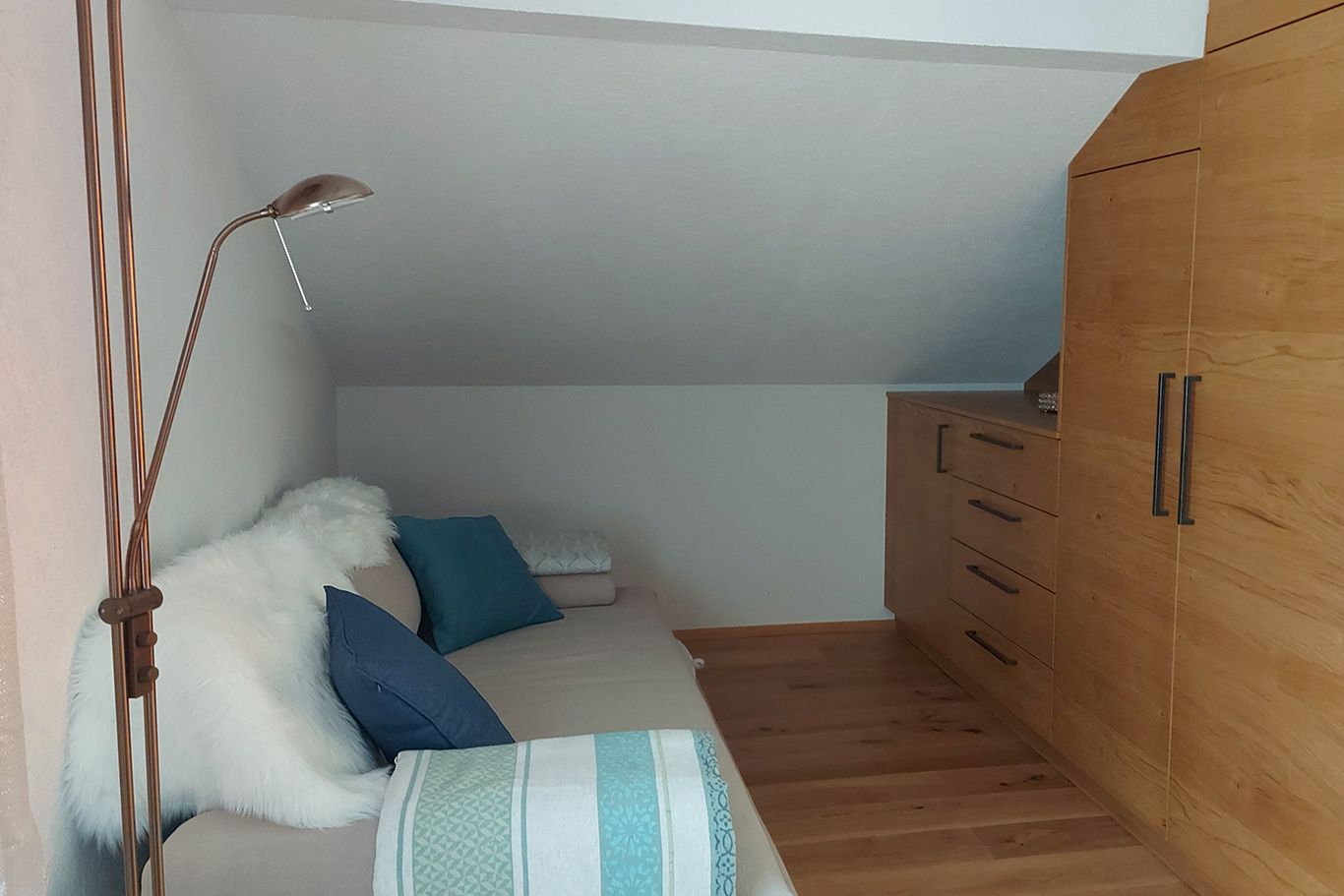 Doppelzimmer im Obergeschoss mit Ausziehcouch, Holzboden und Schrank.