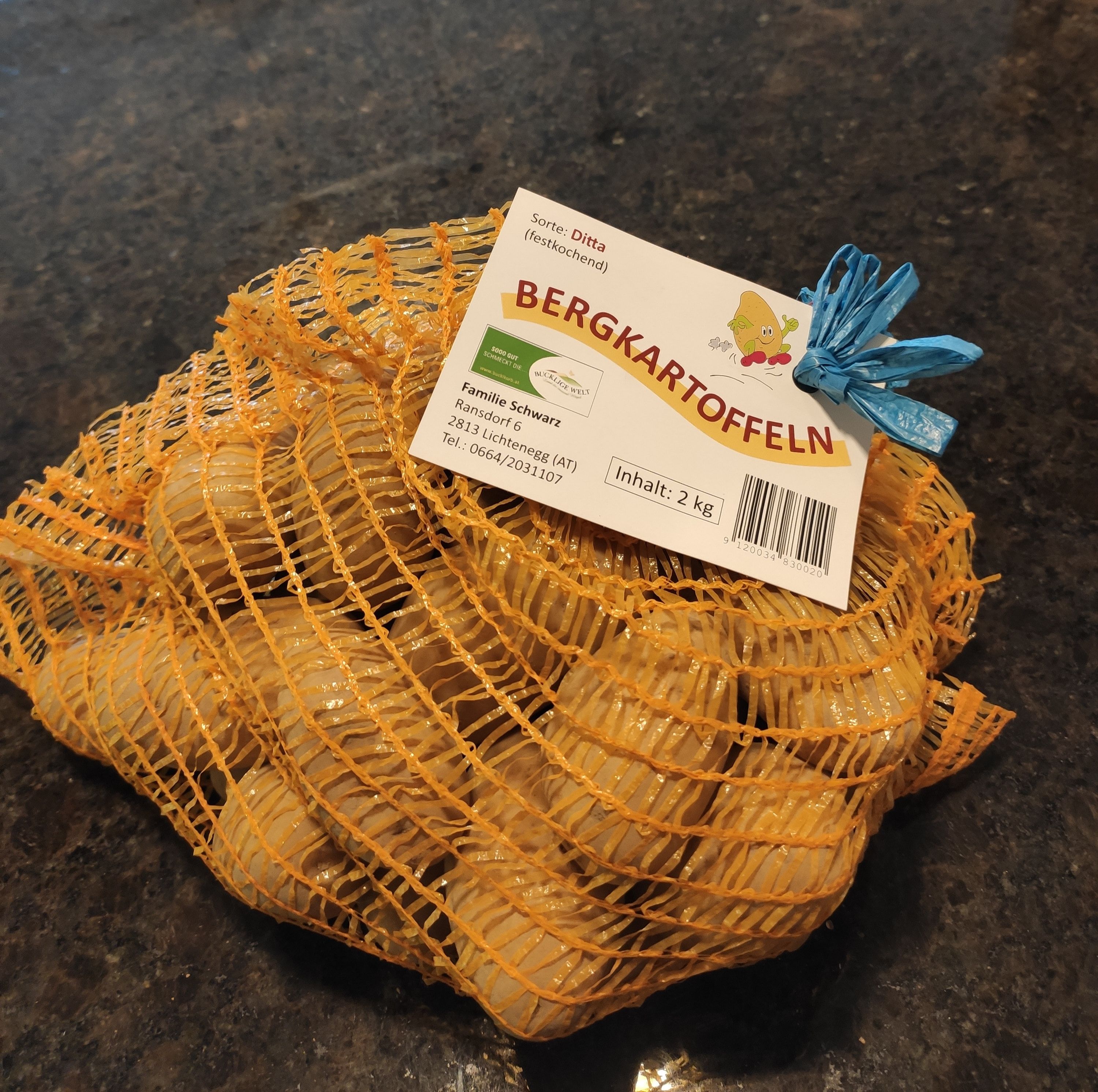 Ein Sack mit Bergkartoffeln auf dunkelgrauem Hintergrund.