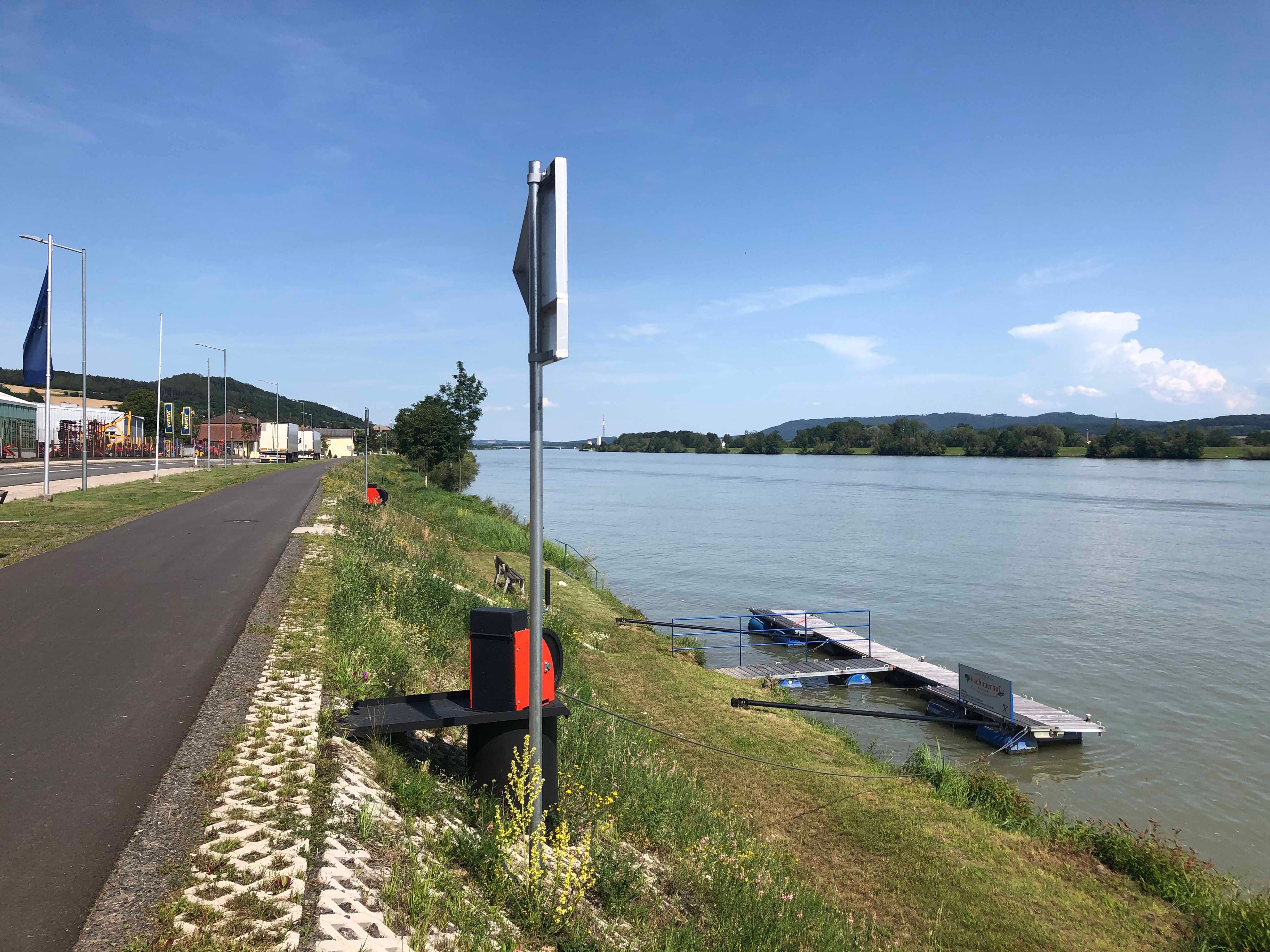 Anlegesteg am Ufer der Donau in Marbach, umgeben von grüner Landschaft und blauem Himmel.