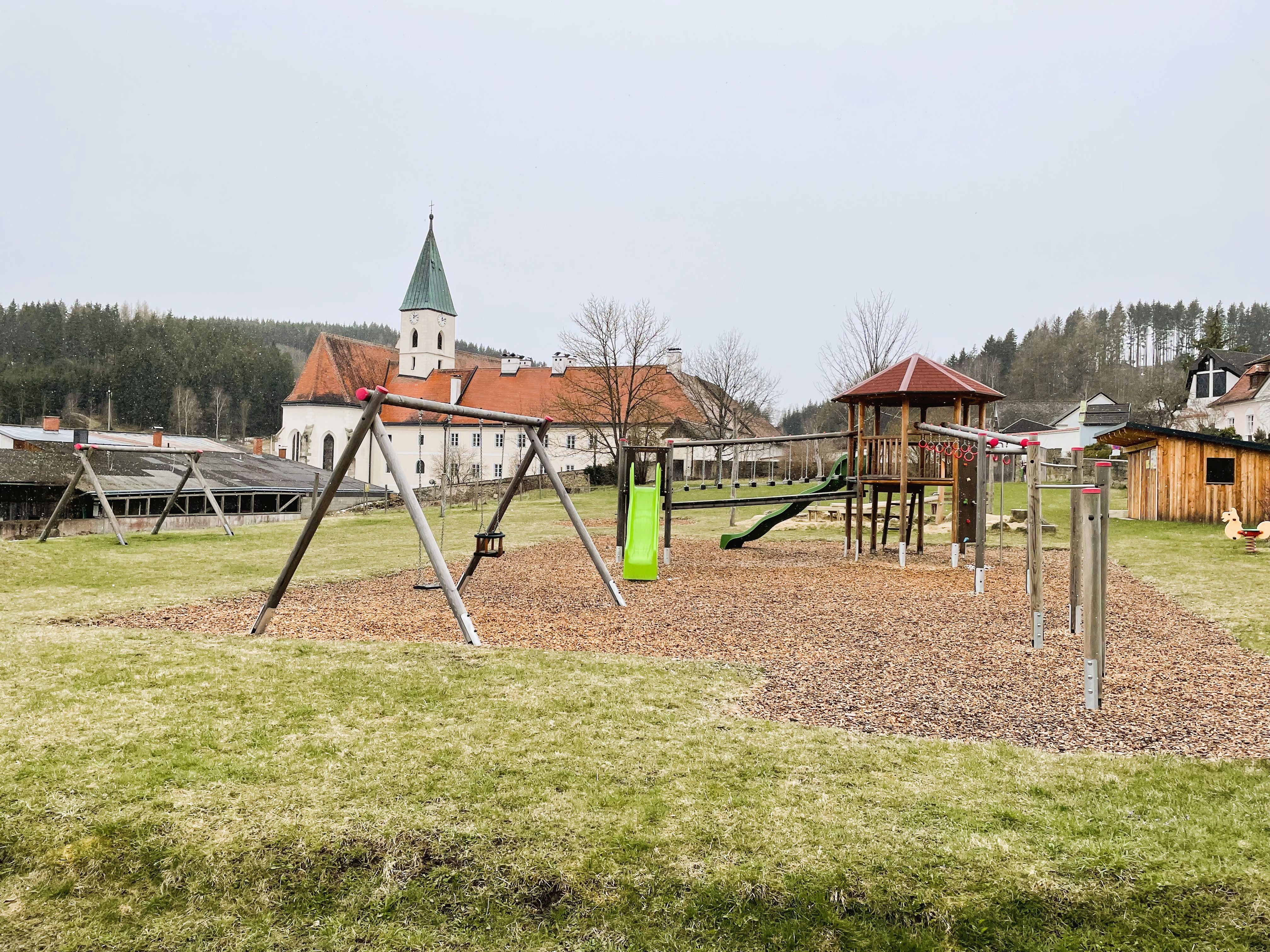 Spielplatz mit Kirche im Hintergrund in Schönbach