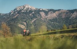 Zwei Radfahrerinnen auf dem Traisental-Radweg, Bergpanorama im Hintergrund.