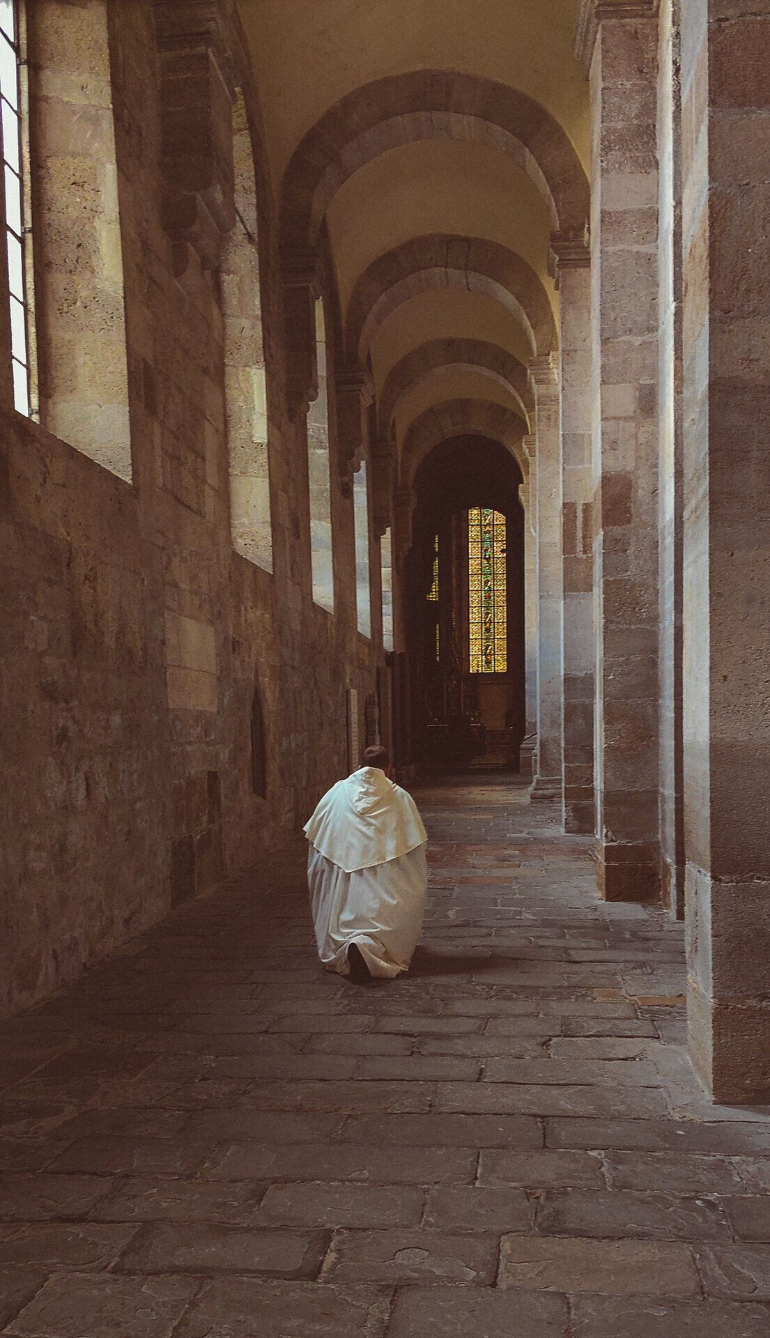 Ein stiller Moment in den ehrwürdigen Hallen des Stifts Heiligenkreuz, wo die sanften Lichtstrahlen durch die bunten Fenster tanzen. Die Atmosphäre ist geprägt von einer tiefen Spiritualität und der Ruhe, die nur an solchen heiligen Orten zu finden ist.