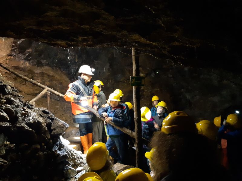 Gruppe von Menschen mit Helmen in einem Schaubergwerk.