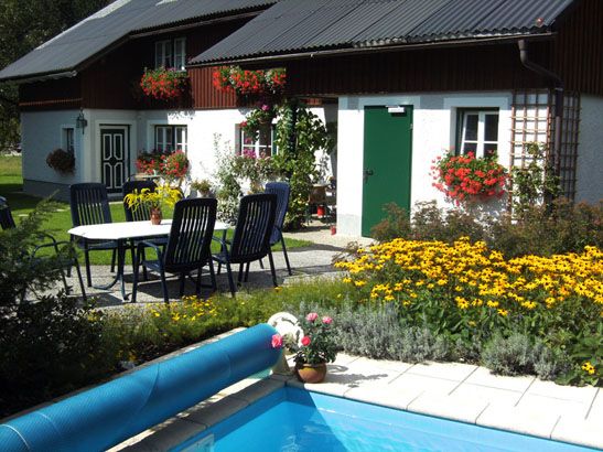 Ferienhaus mit Garten, Pool und Blumen.