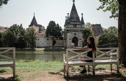 In der warmen Sommerluft sitzt eine junge Frau entspannt auf einer Bank und genießt den Blick auf die majestätischen Gebäude im Hintergrund. Die sanften Wellen des Wassers spiegeln die Schönheit der Natur wider und laden zu einem erholsamen Spaziergang ein. Hier, wo Geschichte und Natur harmonisch verschmelzen, wird jeder Moment zum unvergesslichen Erlebnis.