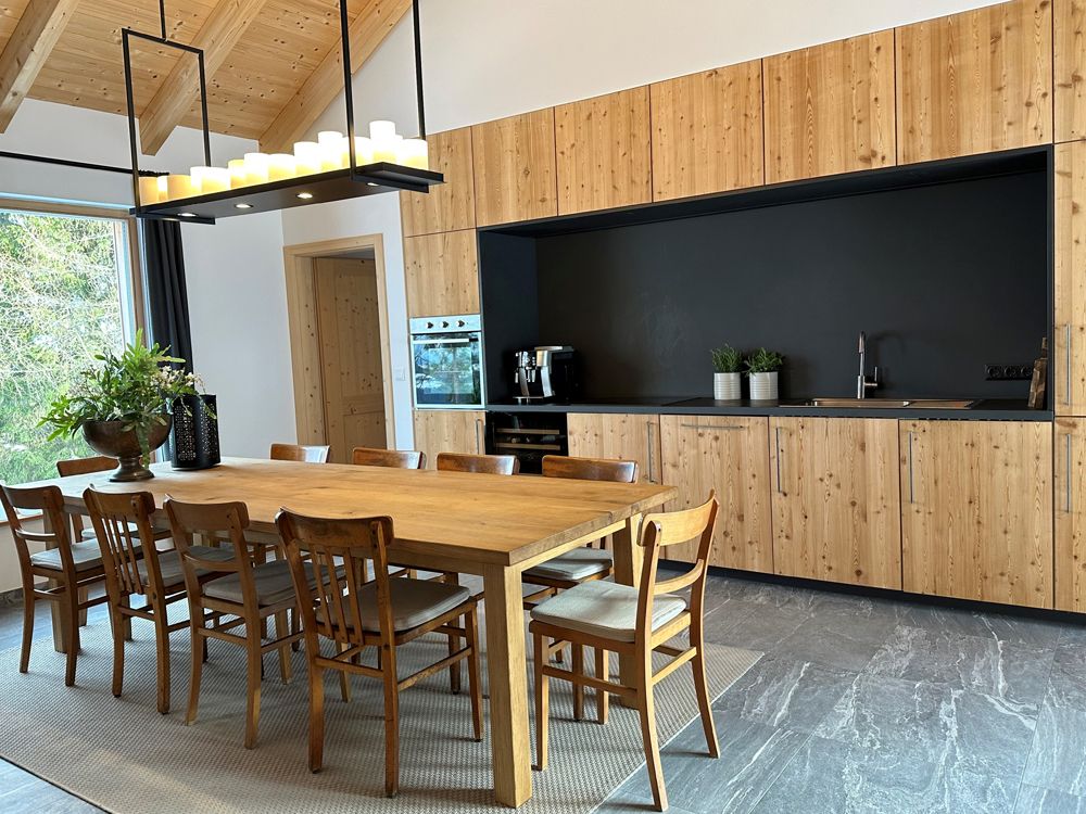 Moderne Küche mit Holzmöbeln und großem Esstisch.