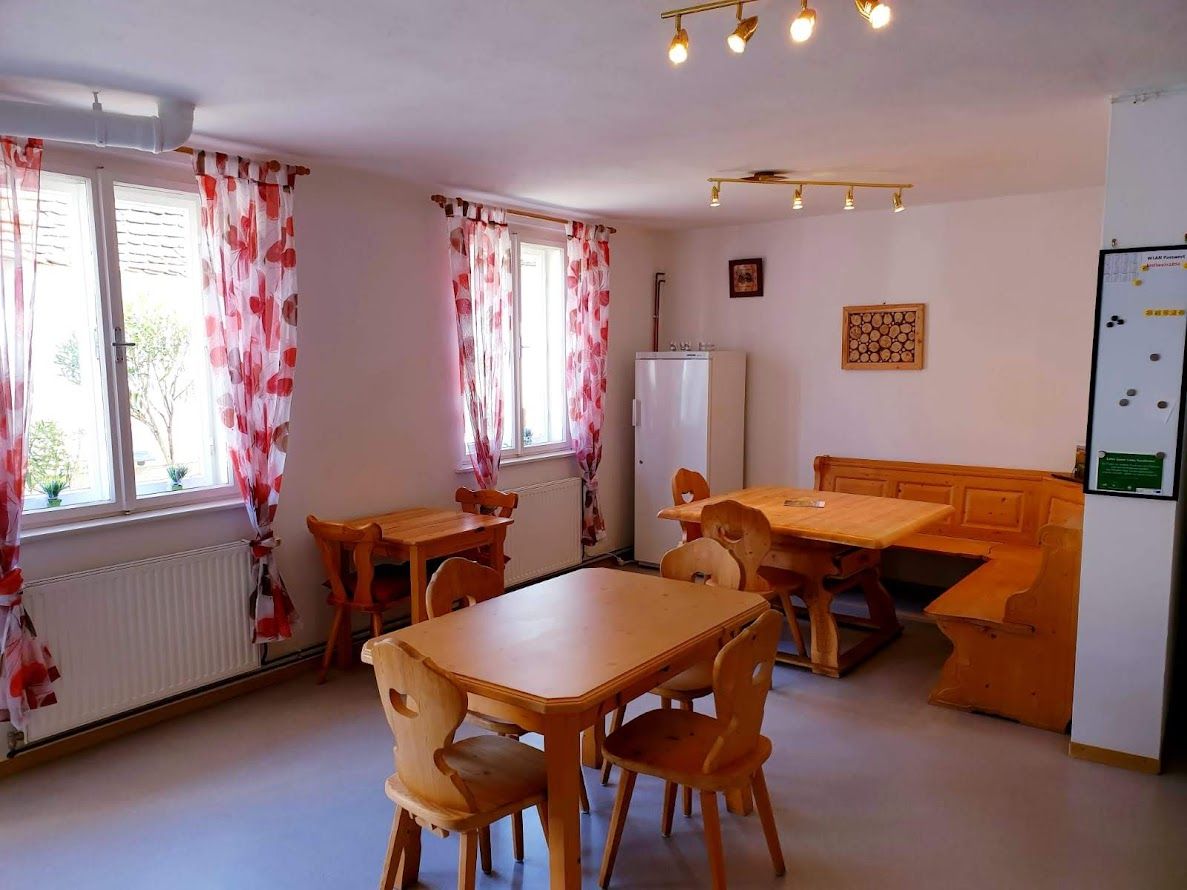 Gemütlicher Raum mit Holzmöbeln und roten Vorhängen.