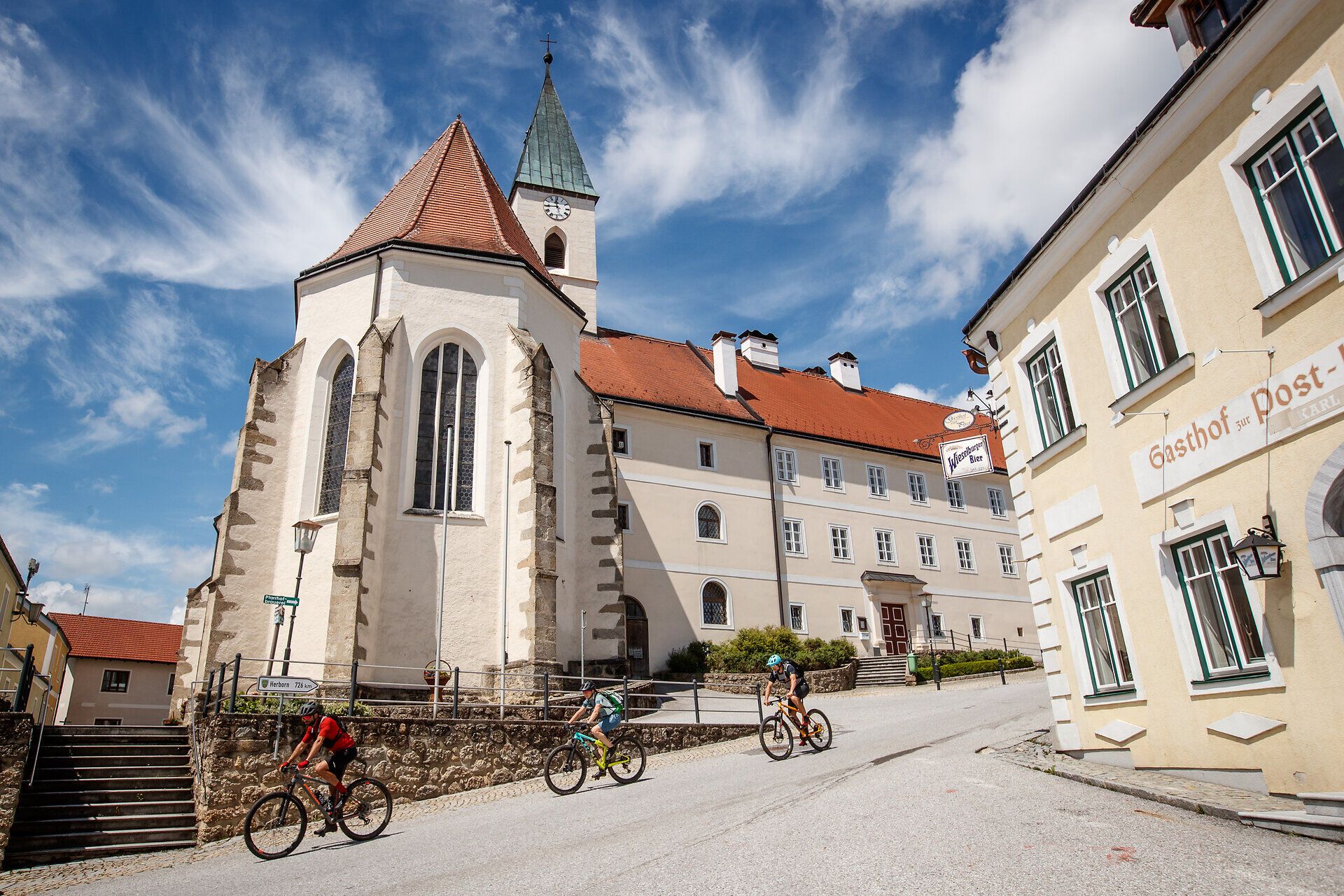 Die sanften Hügel laden zu einem unvergesslichen Abenteuer ein, während die malerische Architektur der Umgebung eine harmonische Kulisse bietet. Radfahrer gleiten die Straße hinauf, um die atemberaubenden Ausblicke auf die umliegende Natur zu genießen. Hier, wo Tradition und Natur aufeinandertreffen, wird jeder Moment zum Erlebnis.