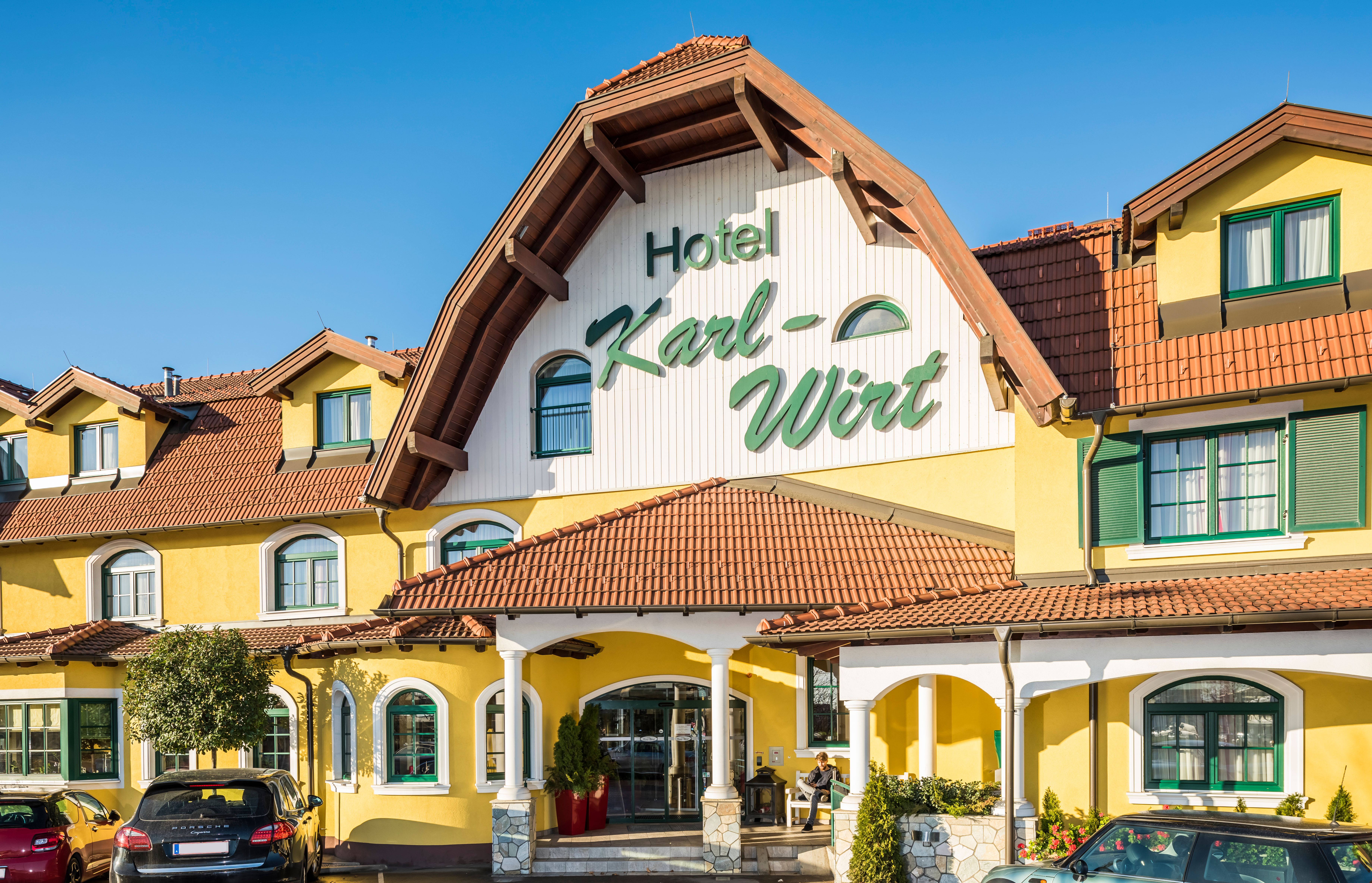 Gelbes Hotelgebäude mit dem Schriftzug 'Hotel Karl-Wirt' auf dem Giebel.