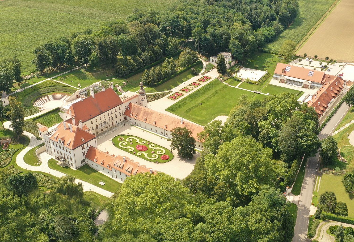 Luftaufnahme von Schloss Thalheim mit umliegenden Gärten und Gebäuden.