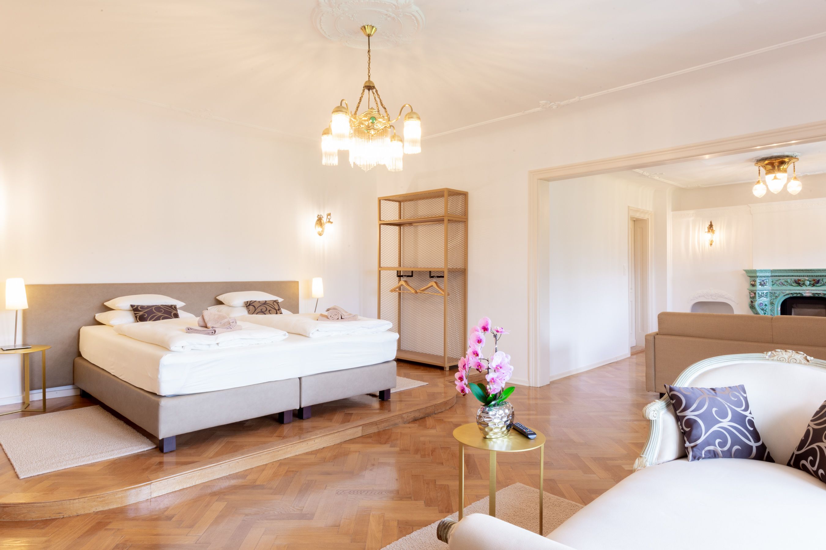 Elegantes Schlafzimmer mit Doppelbett, Kronleuchter und Kamin.