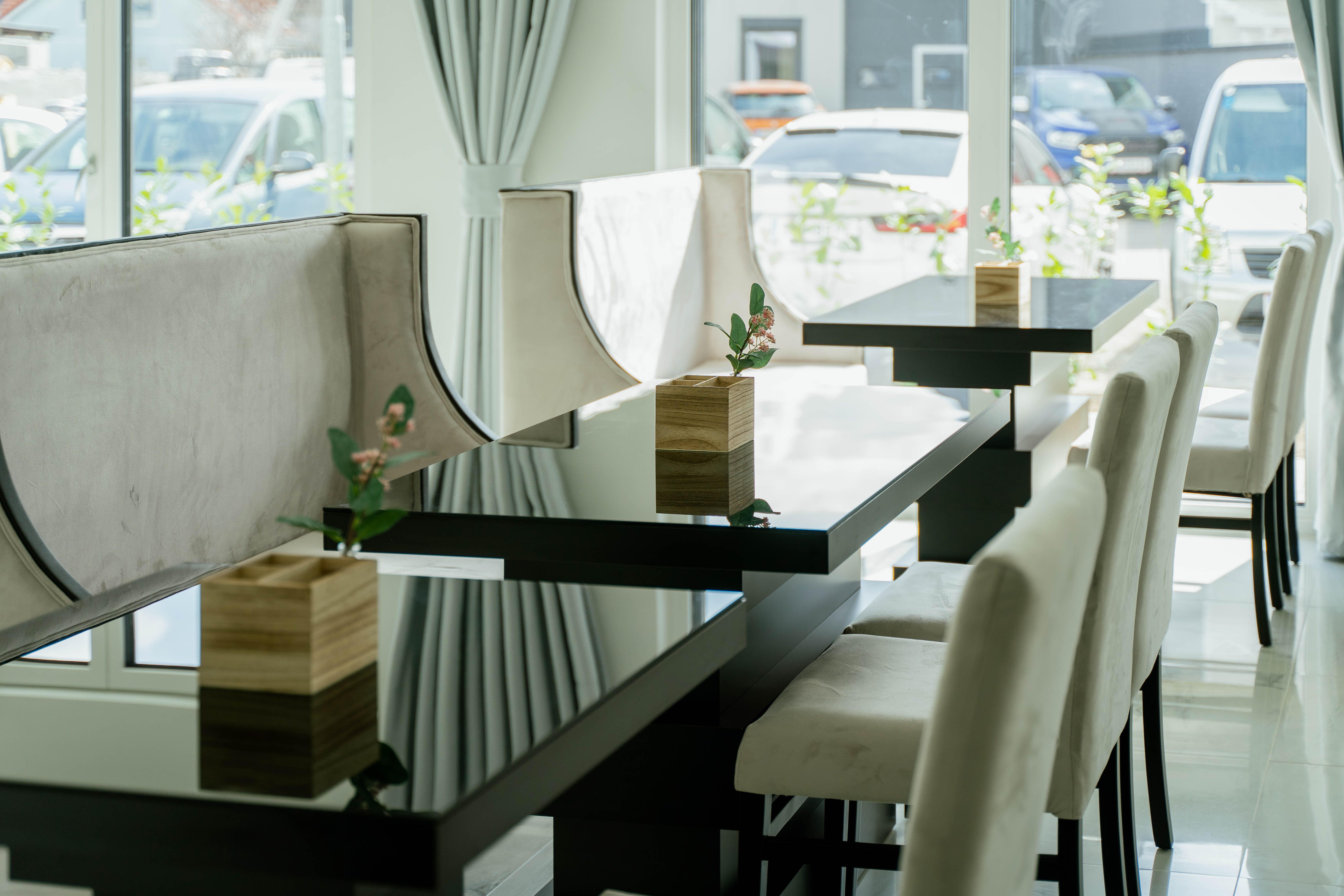 Elegantes Hotelrestaurant mit modernen Tischen und Stühlen, dekoriert mit kleinen Pflanzen in Holzkästen.