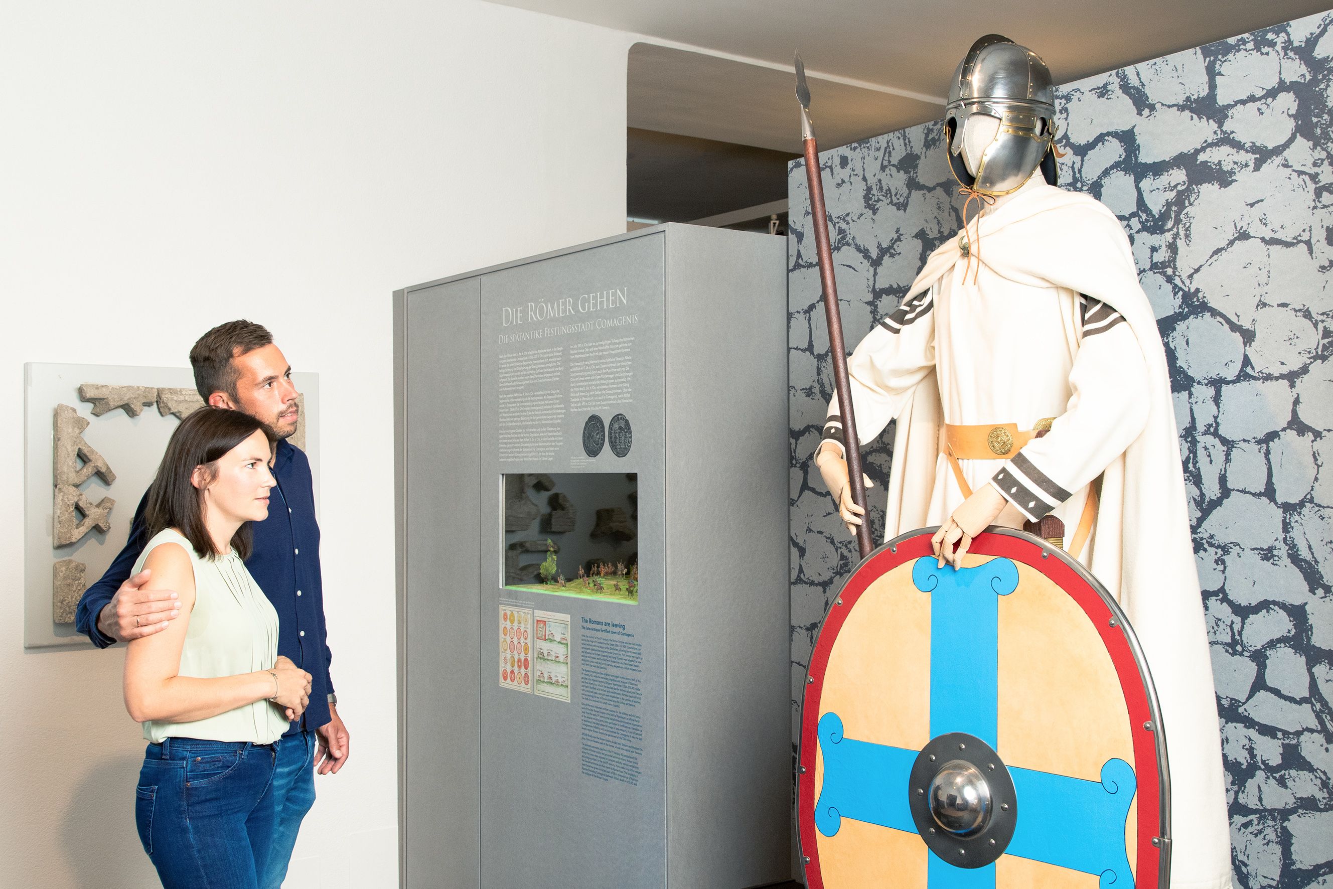 Ein Paar betrachtet eine römische Soldatenfigur im Stadtmuseum Tulln.