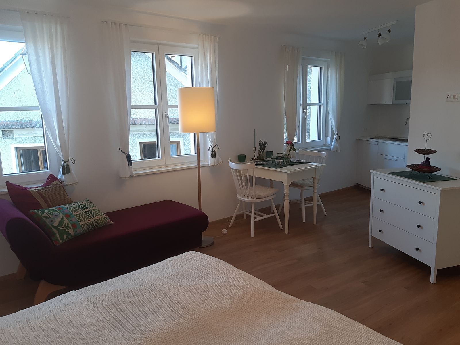 Helles Apartment mit Sofa, Esstisch und Küchenzeile.