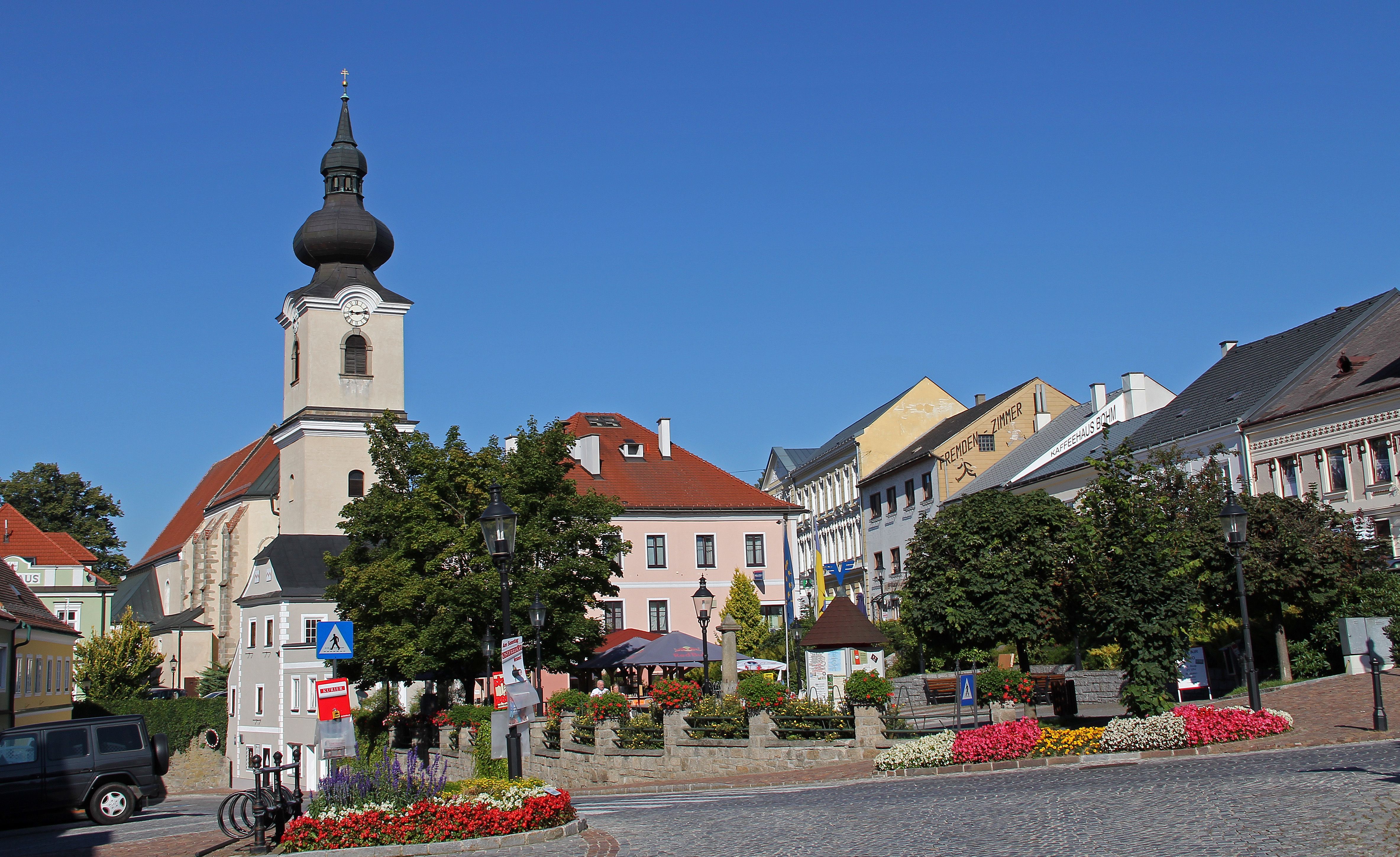 Stadtplatz in Heidenreichstein mit Kirche und bunten Blumenbeeten.
