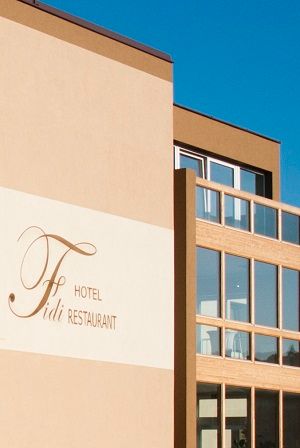Außenansicht eines modernen Gebäudes mit der Aufschrift 'Fidi Hotel Restaurant'.