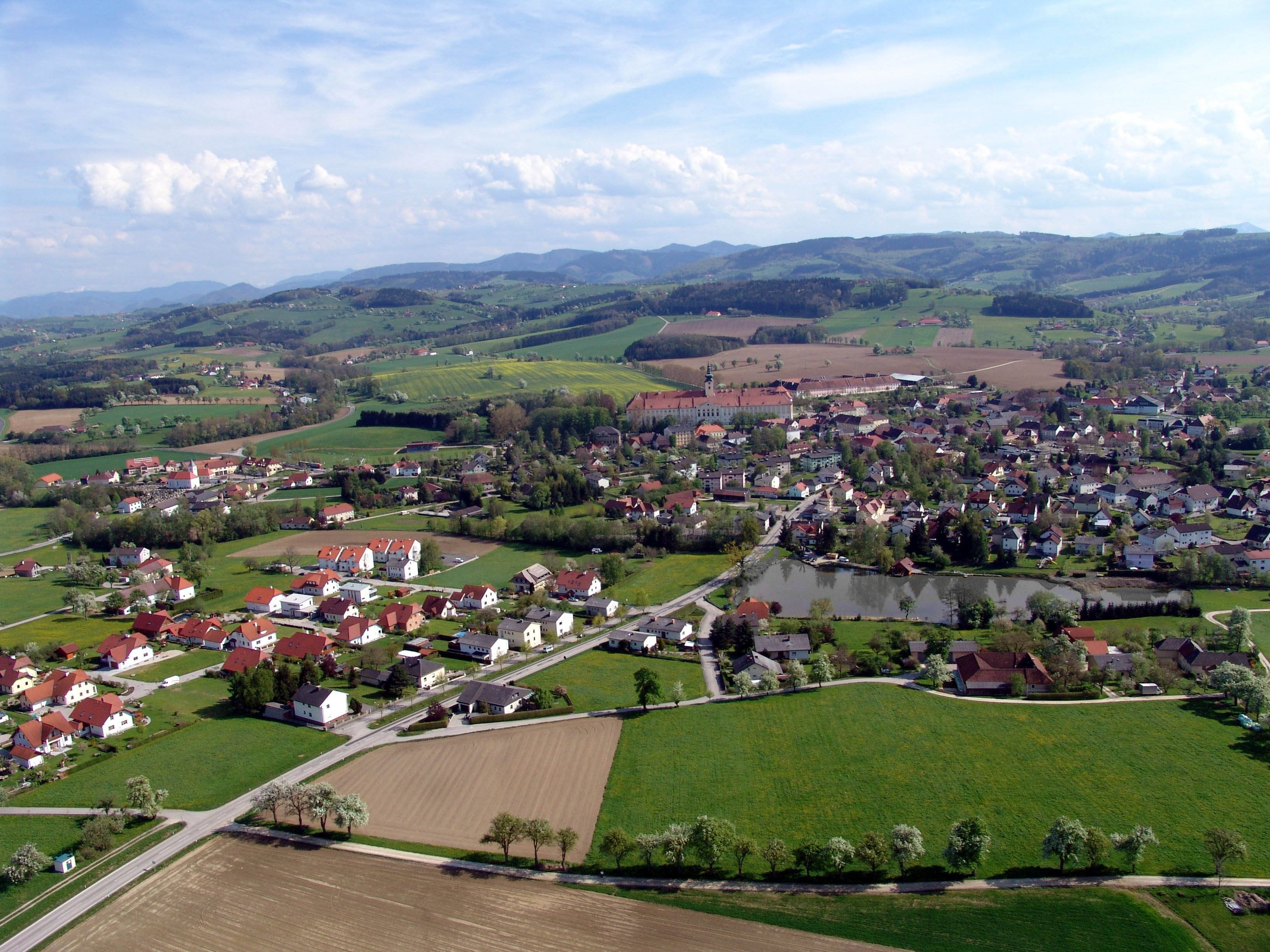Luftaufnahme von Seitenstetten mit Feldern, Häusern und Hügeln im Hintergrund.