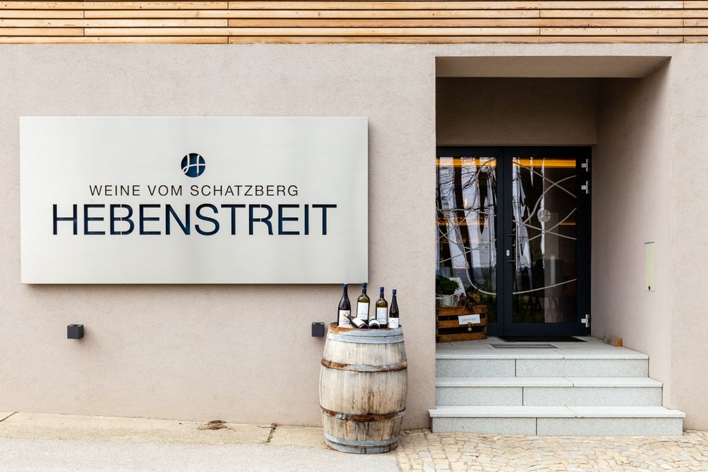 Eingang zu Hebenstreit Weine mit Schild und Weinfass.