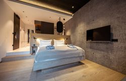 Innenansicht eines modernen Restaurants mit großen Fenstern und Blick auf bewaldete Hügel.