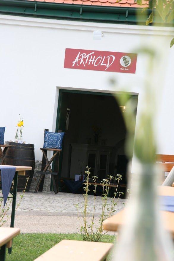 Eingang zu einem Weinkeller mit Schild 'Arthold'.
