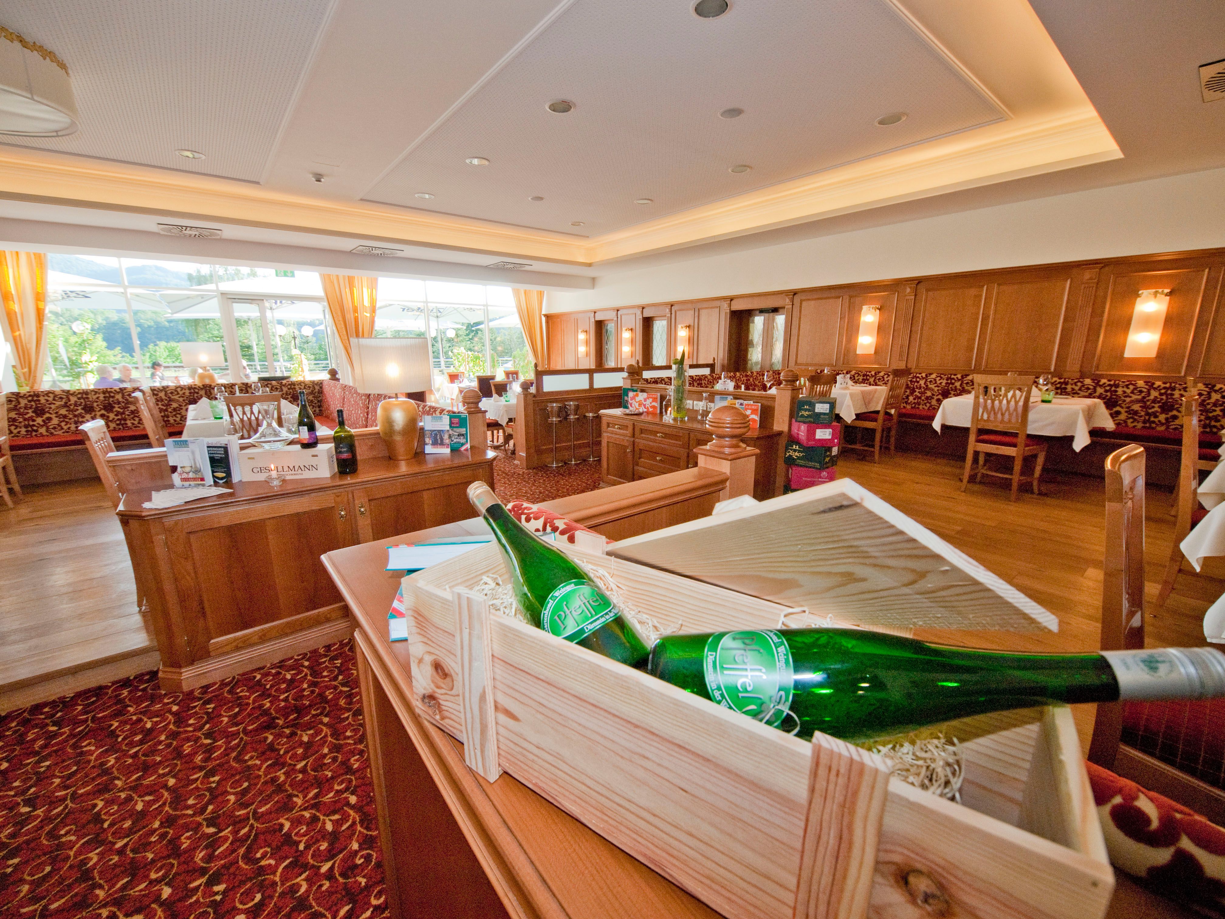 Innenansicht eines eleganten Restaurants mit Holzmöbeln und Weinflaschen.