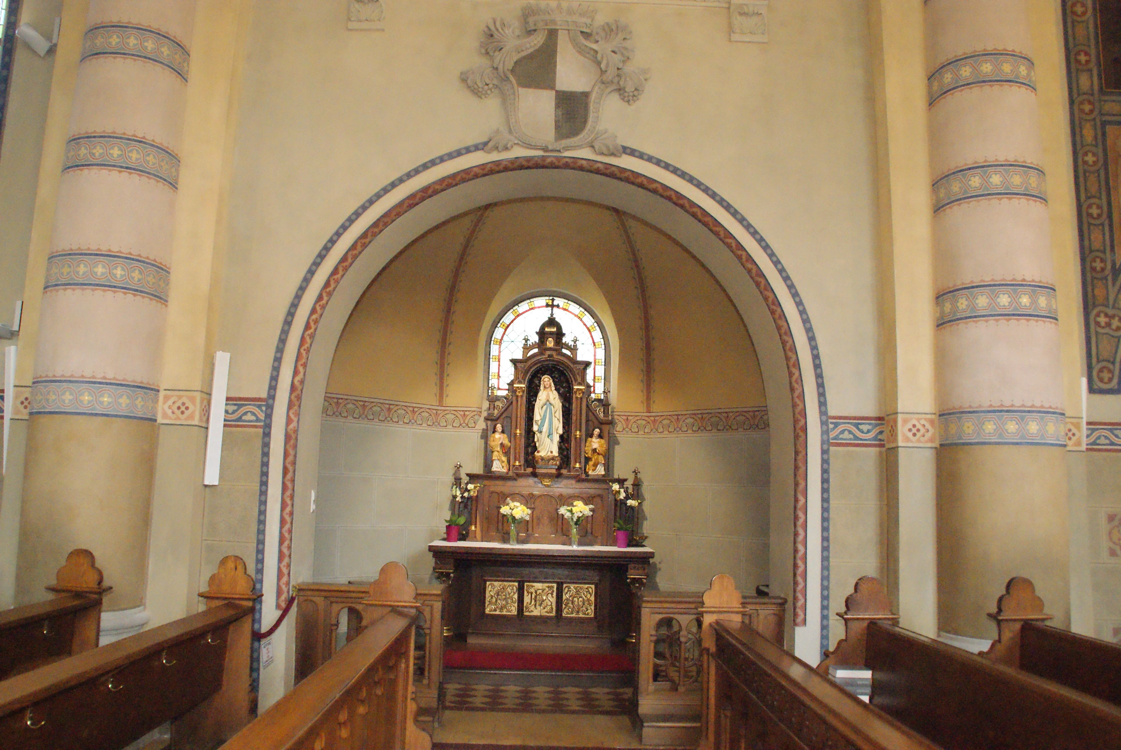 Innenansicht einer Kirche mit einem Altar und einer Marienstatue.