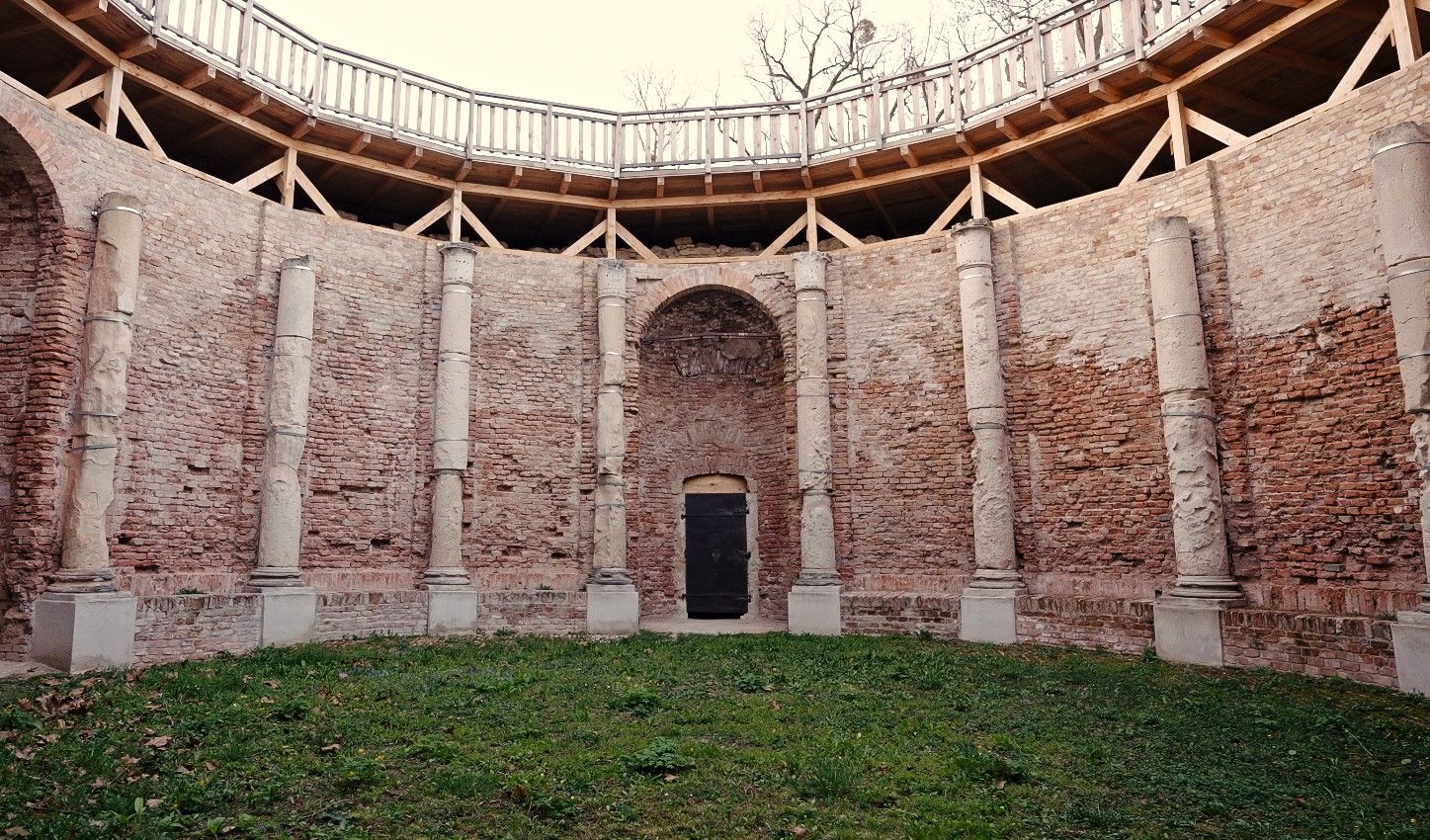 Innenhof mit Backsteinmauern und Säulen, umgeben von einem hölzernen Geländer.