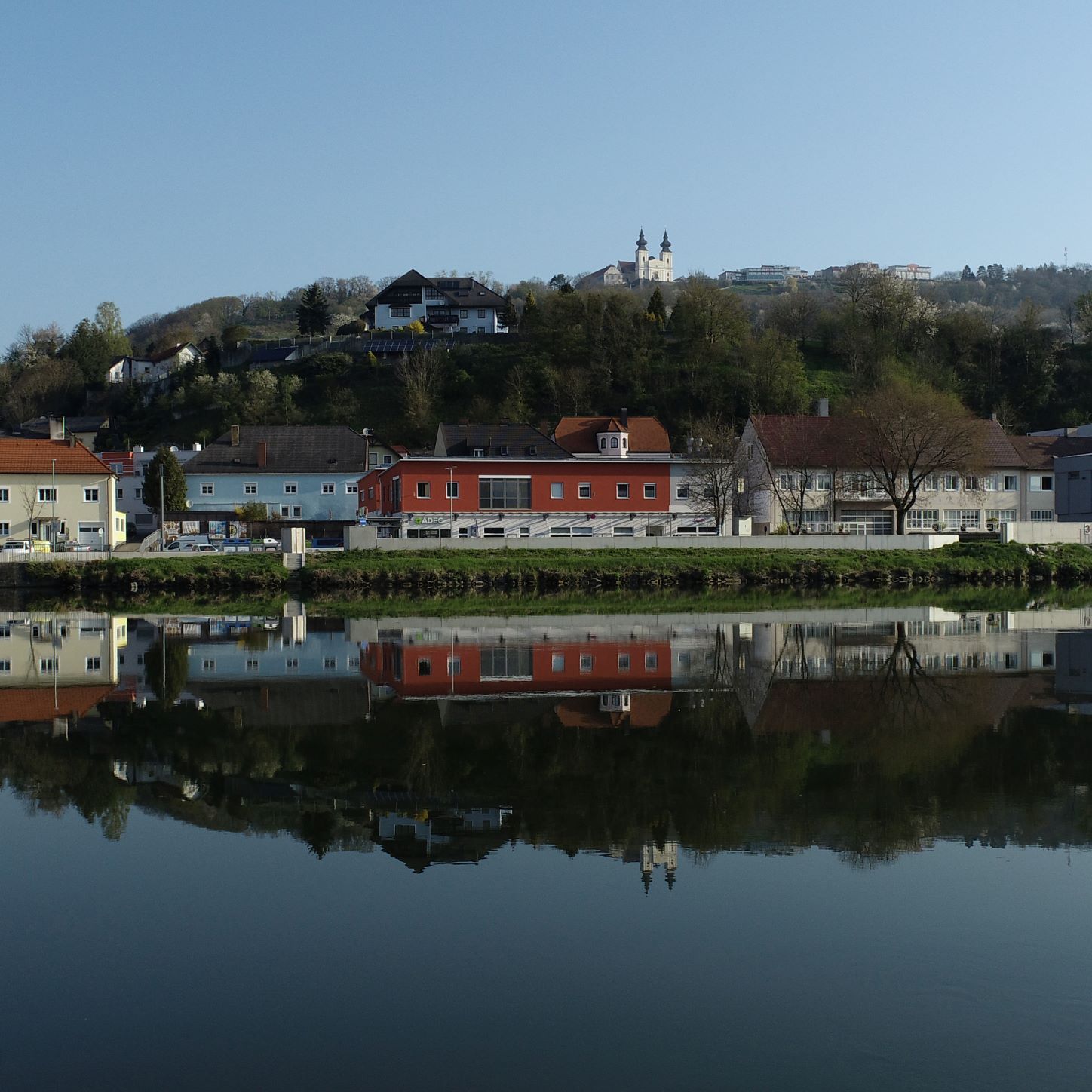 Stadtansicht von Marbach mit Gebäuden und Kirche, die sich im Wasser spiegeln.