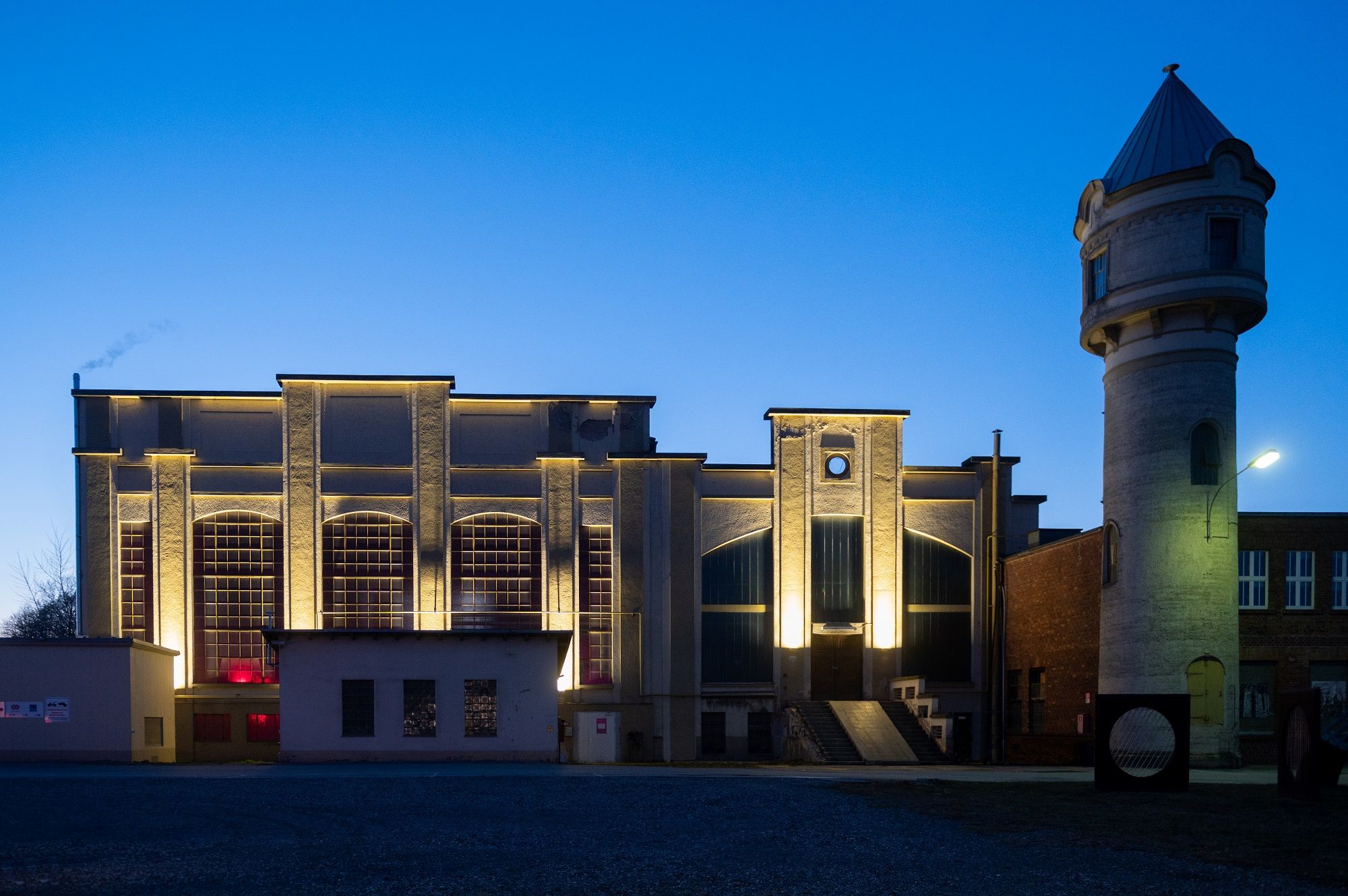 Beleuchtetes Gebäude in St. Pölten bei Dämmerung mit Turm rechts.