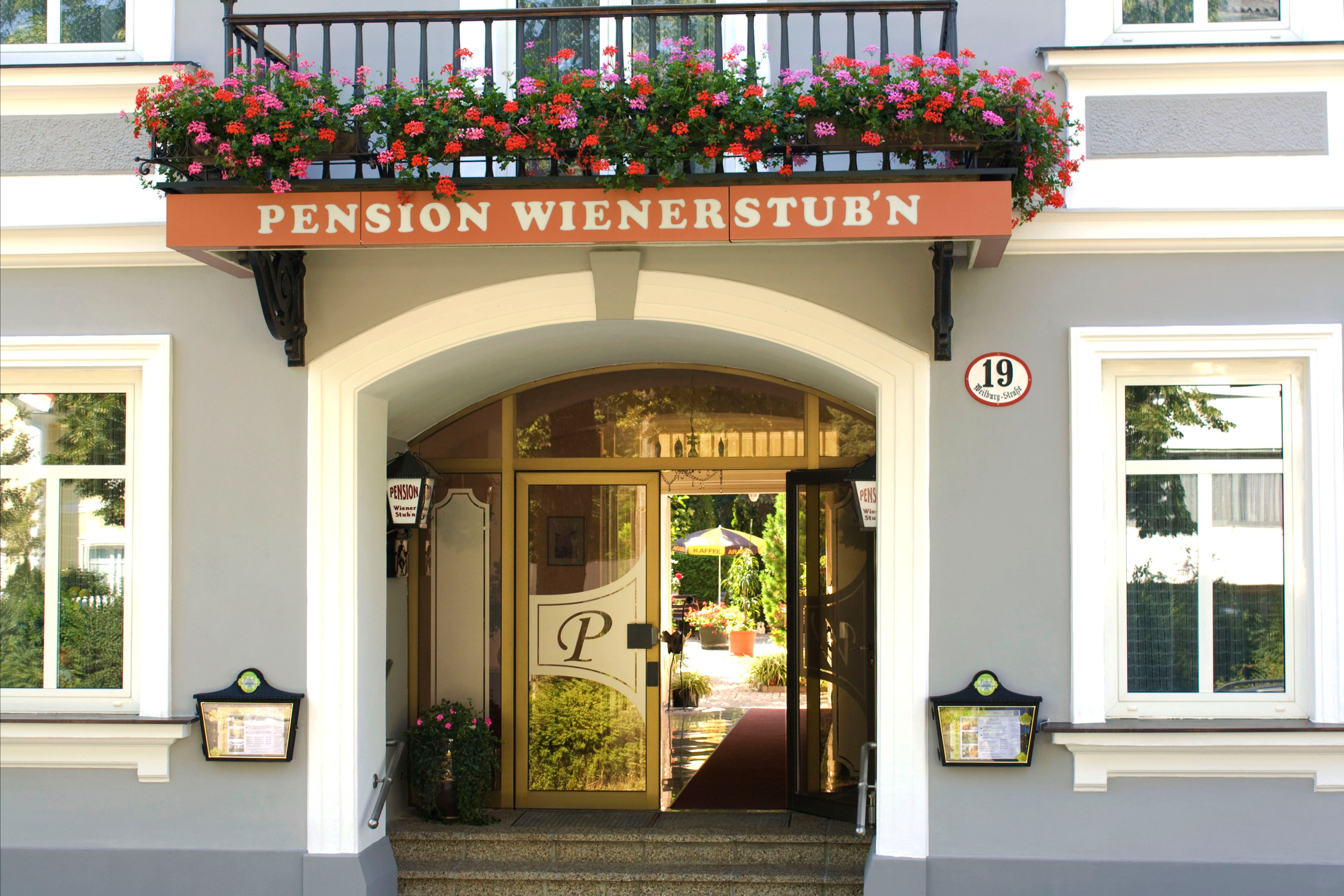 Eingang der Pension Wienerstub'n mit Blumen und Hausnummer 19.