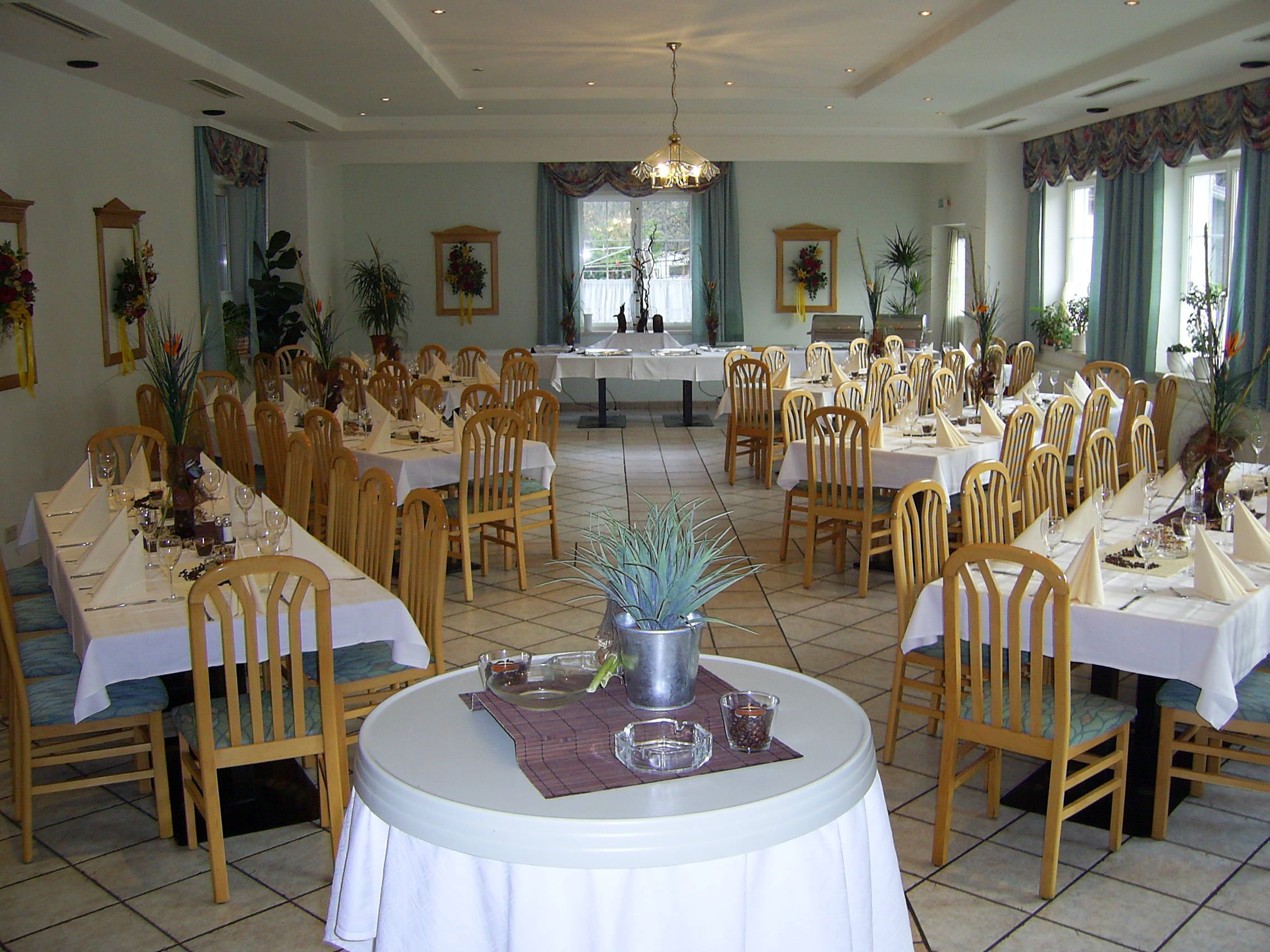 Eleganter Speisesaal mit gedeckten Tischen und Holzstühlen.