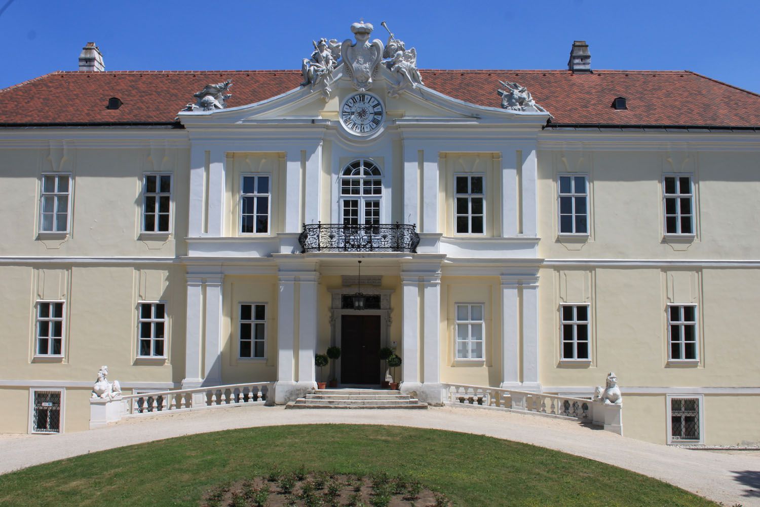 Frontansicht von Schloss Liechtenstein mit Uhr und Skulpturen auf dem Dach.