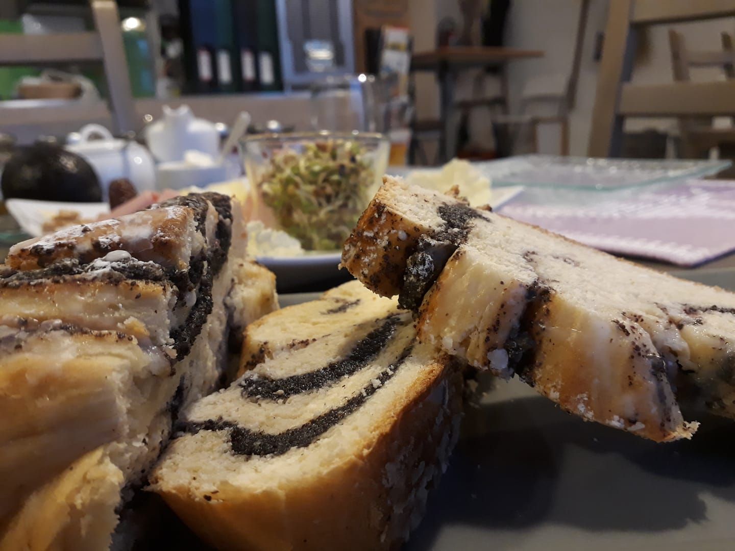 Nahaufnahme von Mohnkuchen auf einem Frühstückstisch mit unscharfem Hintergrund.