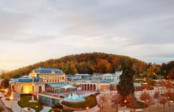 Die sanften Hügel des Wienerwaldes umarmen das elegante Casino, während die bunten Blätter der Bäume im sanften Licht der Abenddämmerung leuchten. Ein Ort, der zum Verweilen einlädt und die Seele mit seiner malerischen Schönheit berührt.