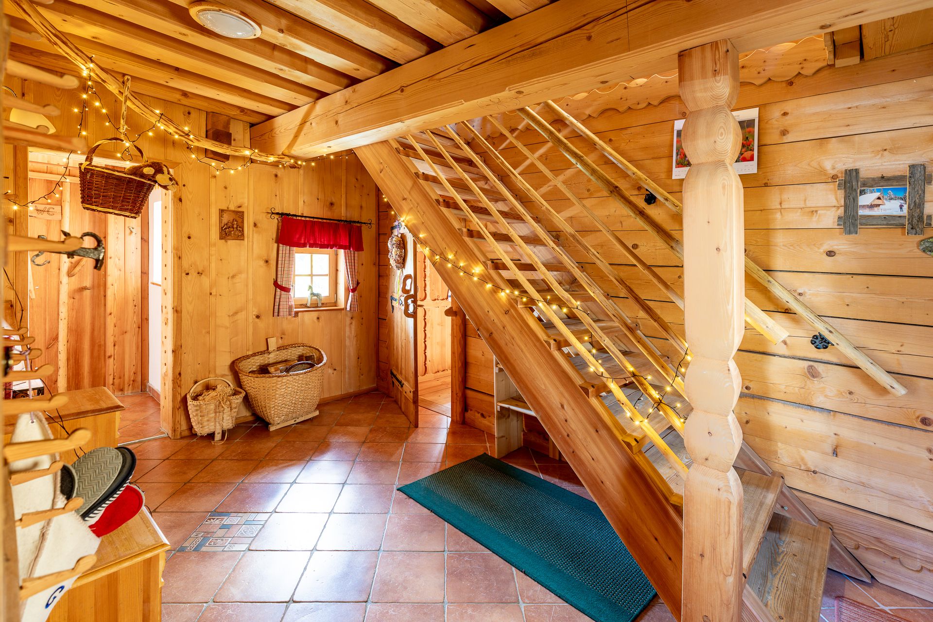 Raum mit Holzvertäfelung, Fliesenboden, einer Treppe und Dekoration.
