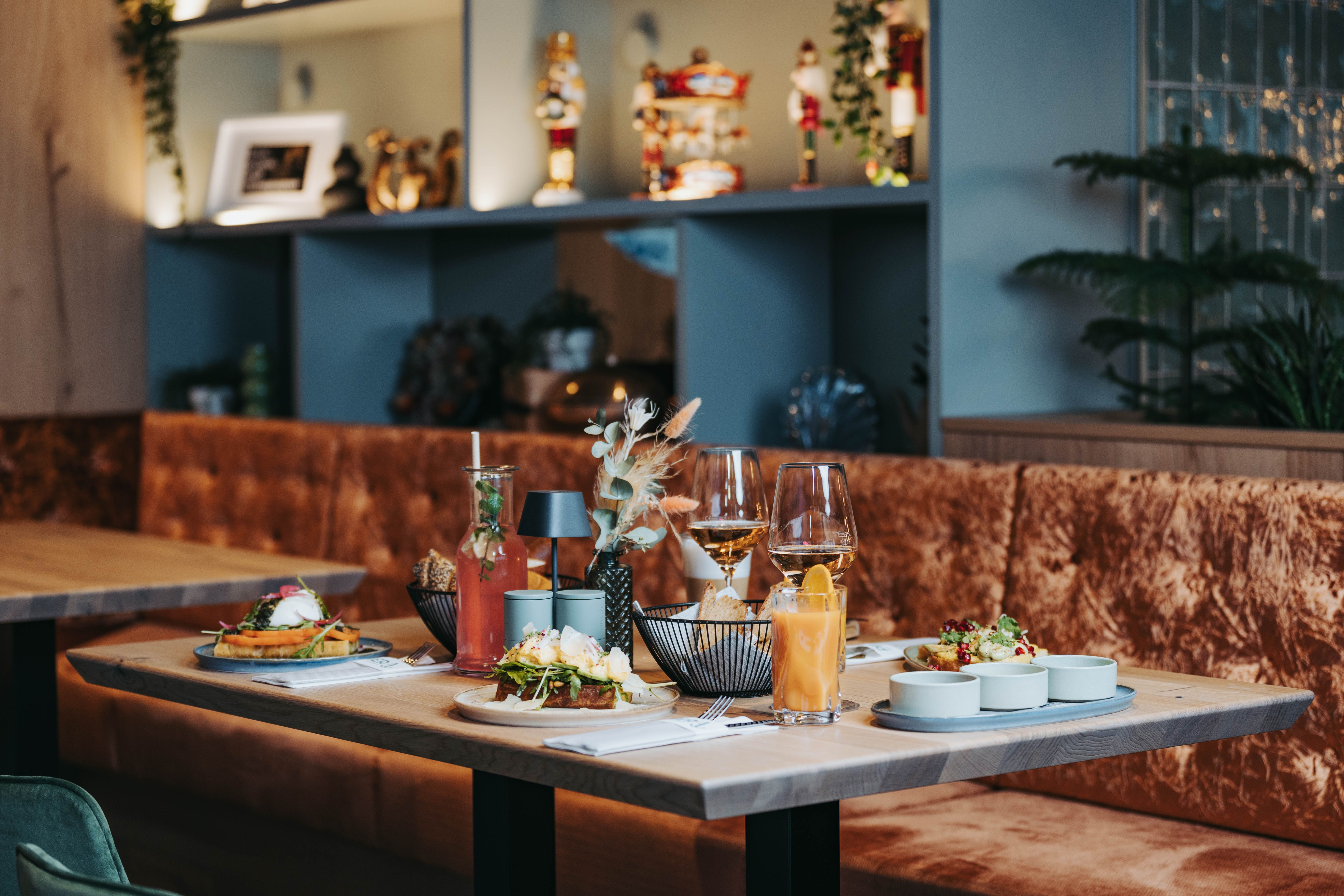 Gedeckter Tisch mit Speisen und Getränken in einem stilvollen Restaurant.