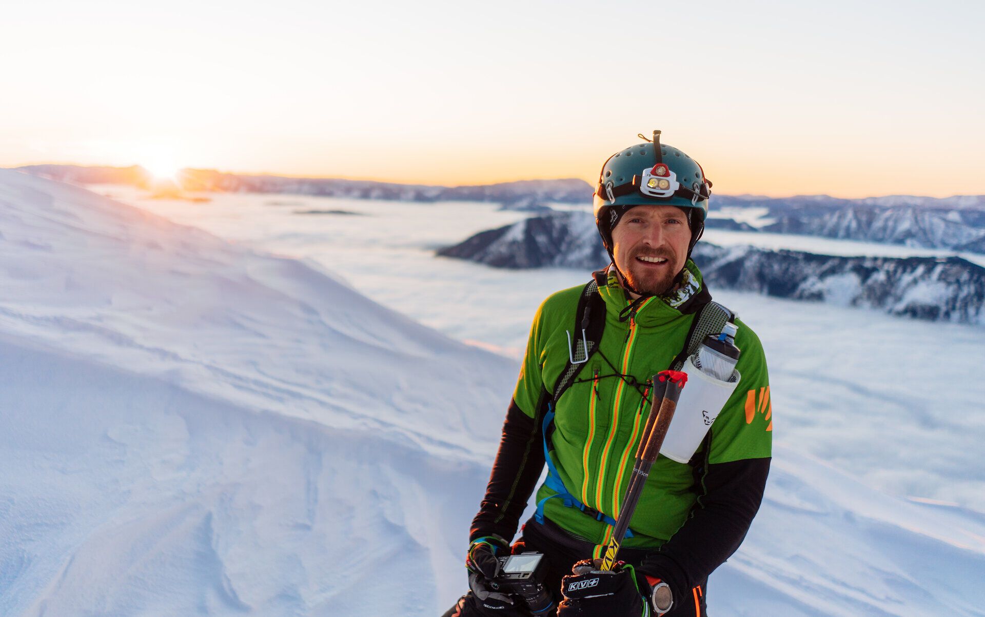 Gerald Demolsky in Skitourenmontur am verschneiten Ötscher, im Hintergrund geht die Sonne auf.
