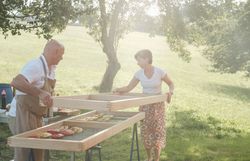 In der warmen Abendsonne bereiten zwei Personen mit Freude eine kulinarische Köstlichkeit vor. Die frische Luft und die idyllische Landschaft schaffen eine einladende Atmosphäre, die zum Genießen und Verweilen einlädt.