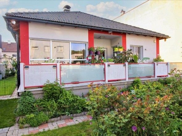 grau rotes Haus mit Balkon und Blumen 