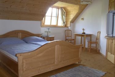 Gemütliches Schlafzimmer mit Holzmöbeln und Dachfenster.