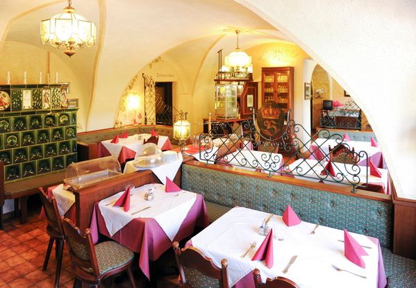 Gemütliche Gaststube mit gedeckten Tischen und traditioneller Dekoration.