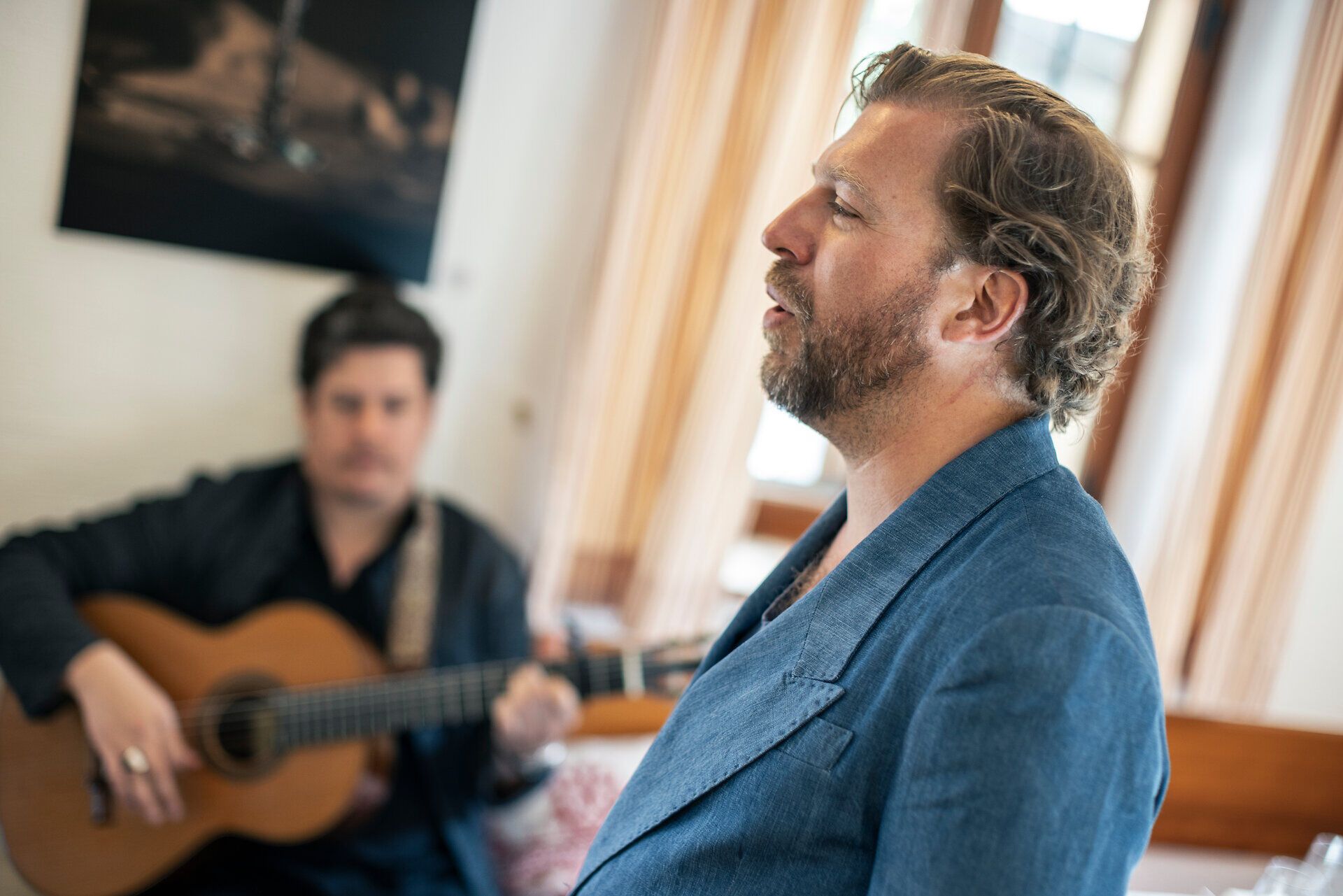 Der Tenor Julian Prégardien singt für die Gäste im Triad. Begleitet wird er von einem Mann mit einer Gitarre.