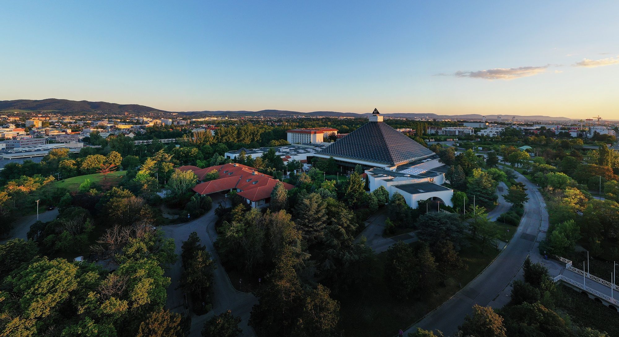 Luftaufnahme des Eventhotel Pyramide mit umliegender Landschaft bei Sonnenuntergang.