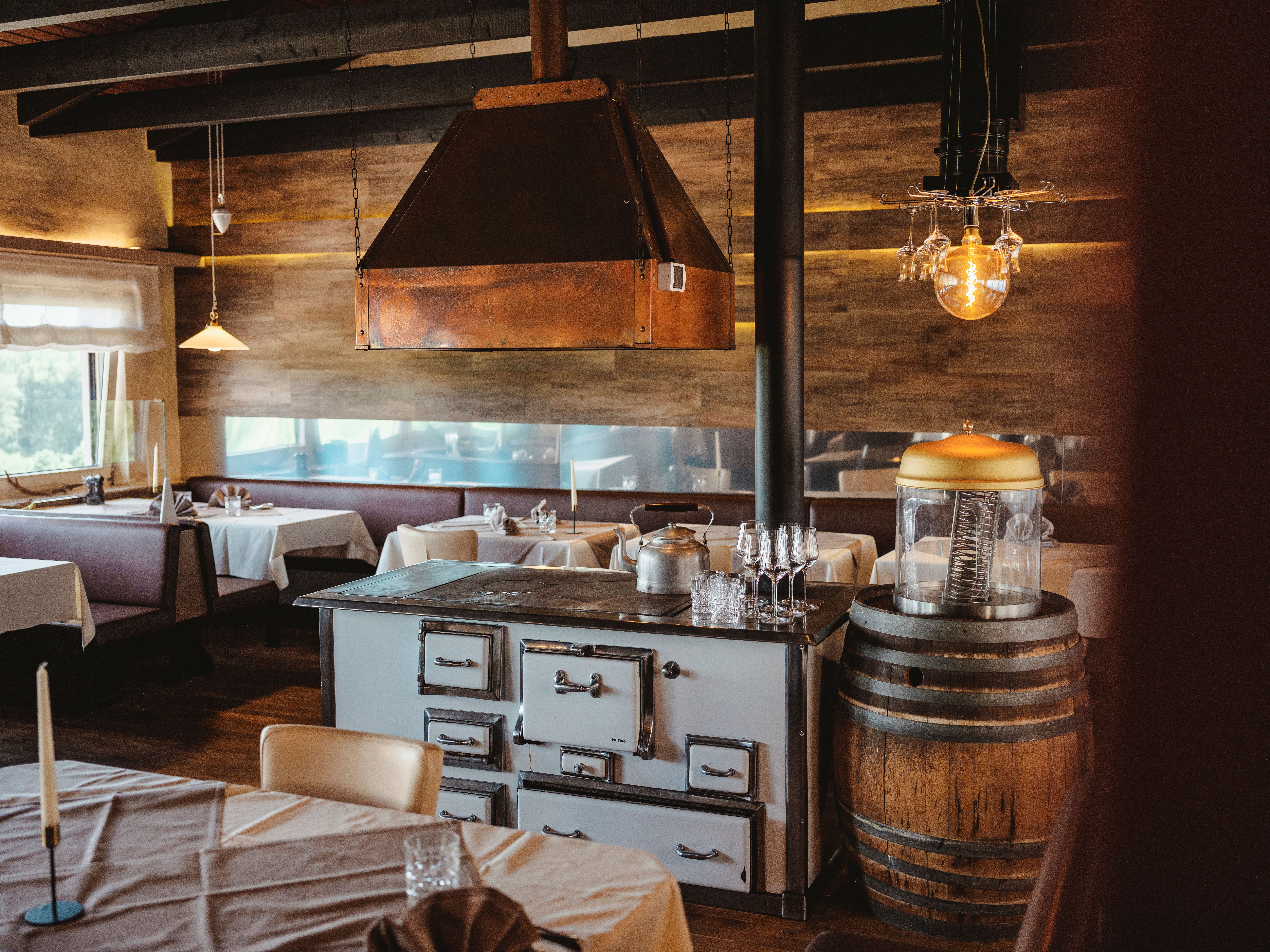 Eine Kellnerin deckt Tische auf einer Terrasse mit Blick auf den Nationalpark Donau-Auen.