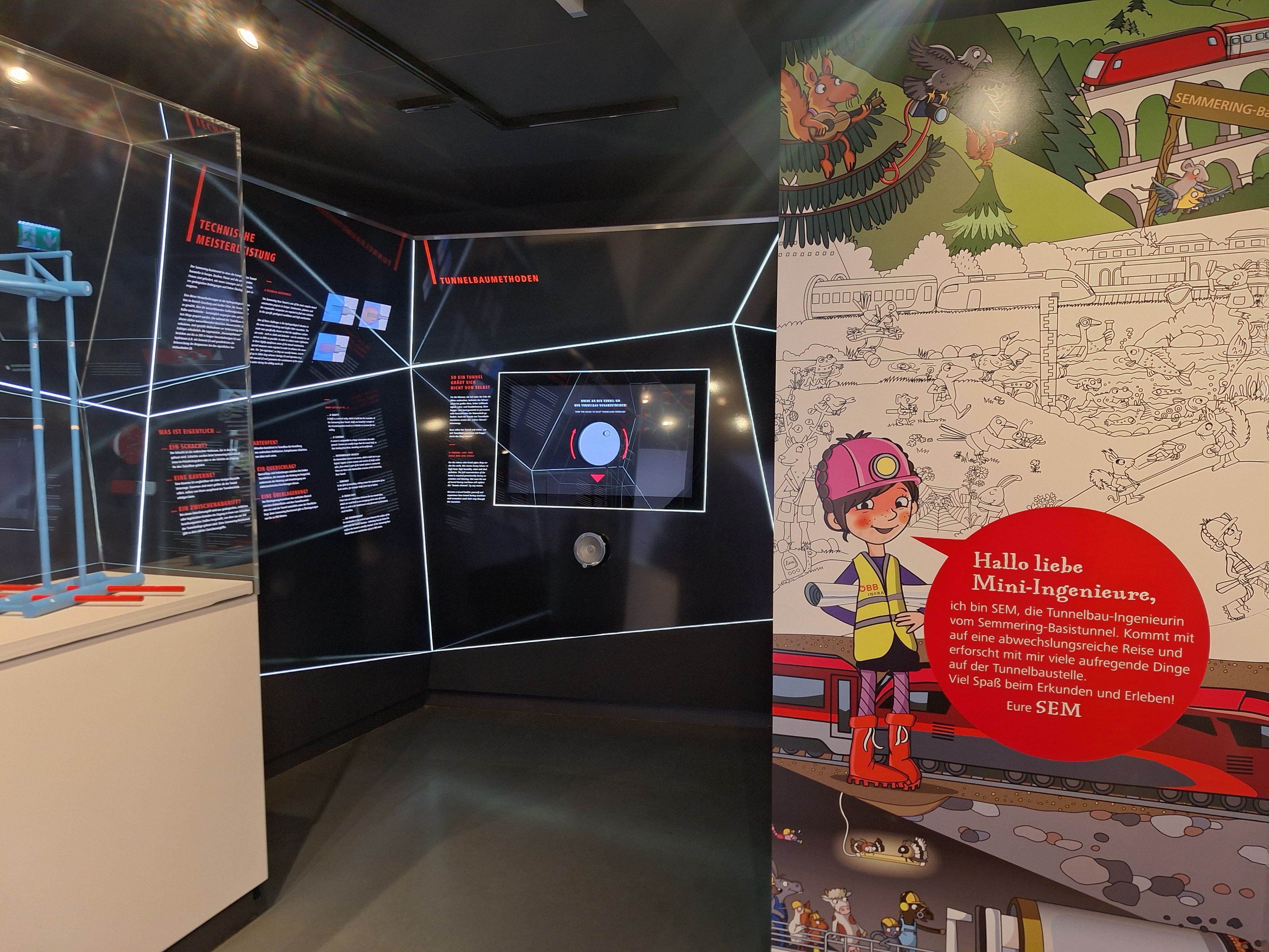 Ausstellung über den Semmering-Basistunnel mit Infotafeln und Kinderillustration.