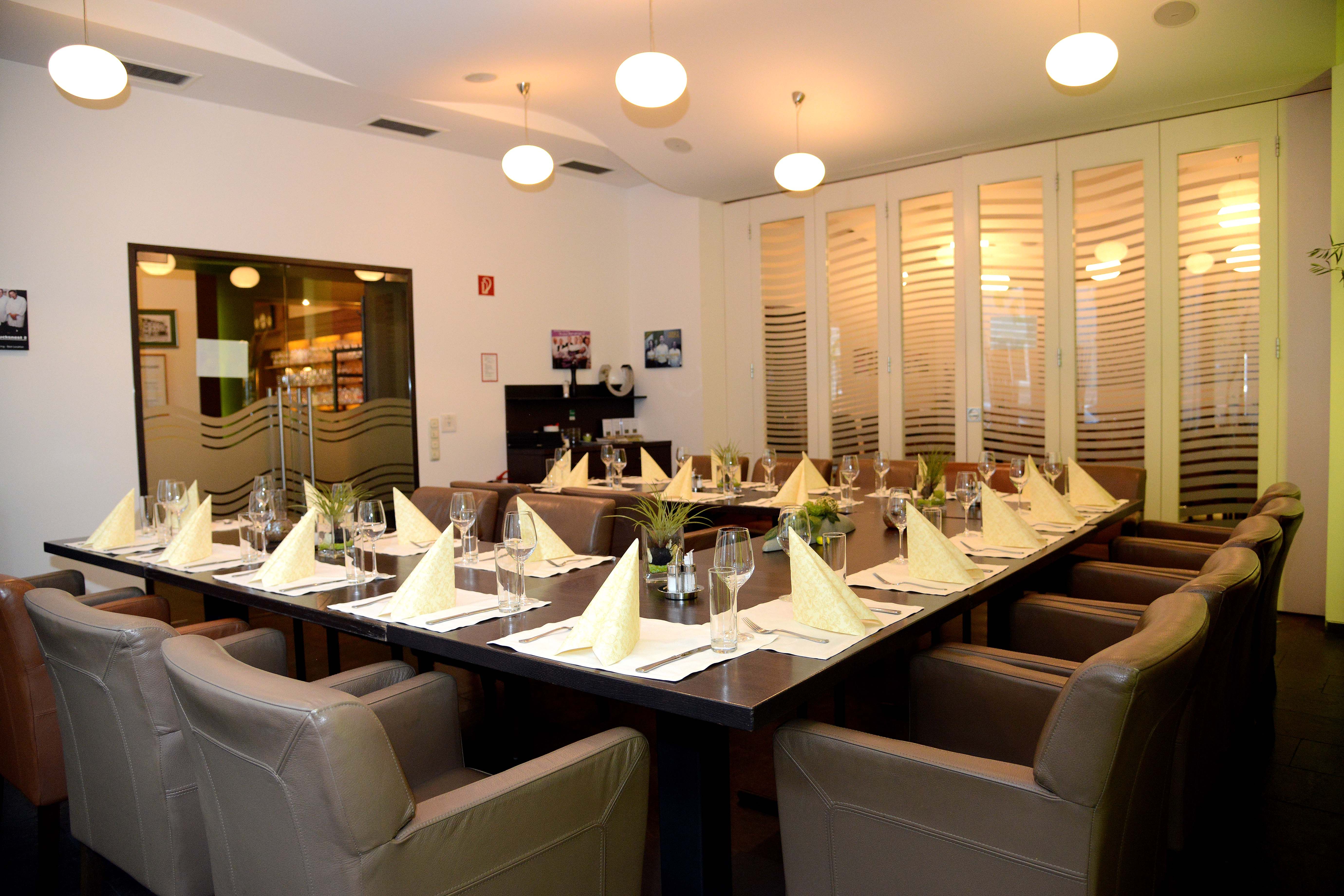 Eleganter Speisesaal mit gedecktem Tisch und Ledersesseln.